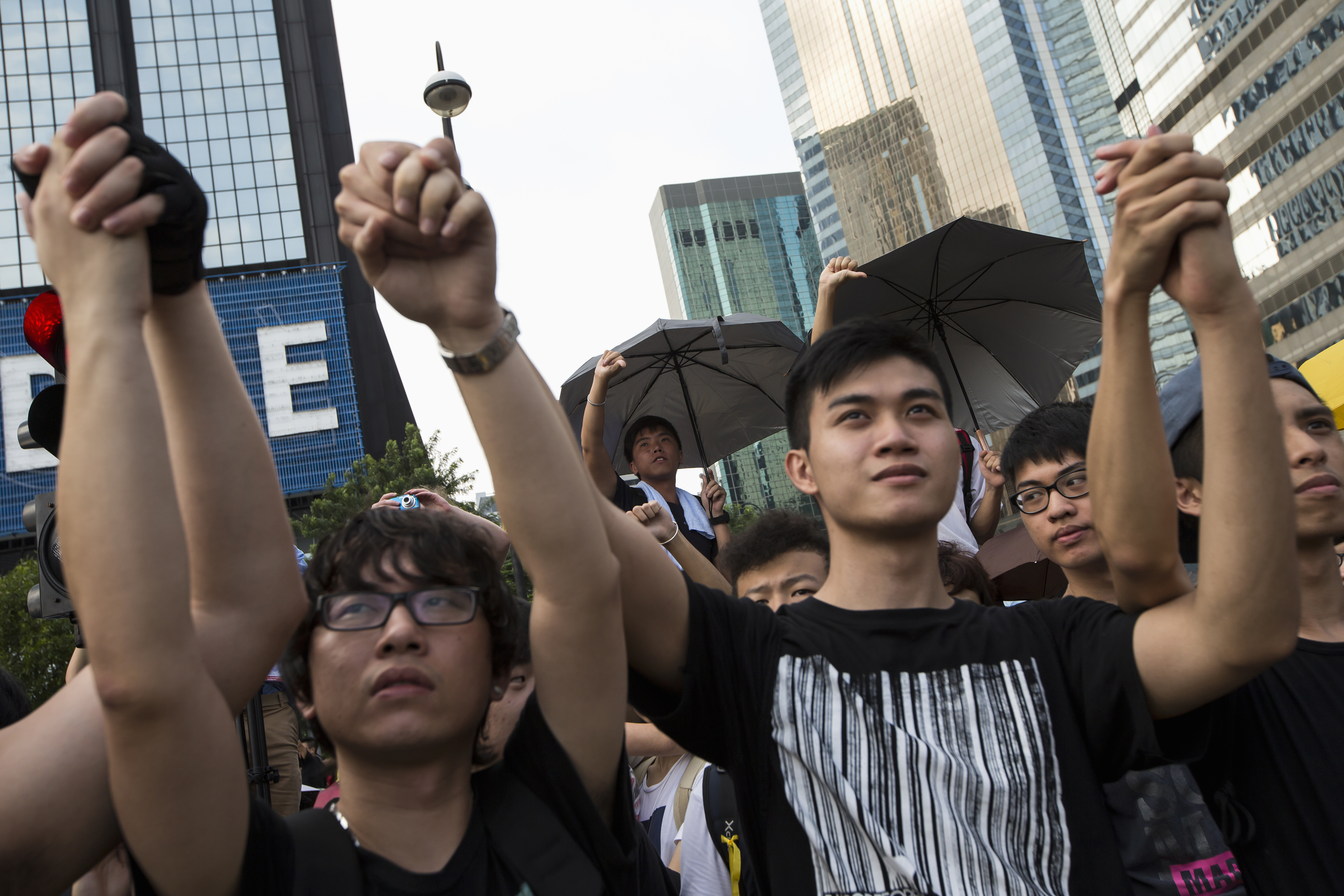 Student protesters gesture outside the Golden Bauhinia Square, venue of the official flag-raising ceremony for celebrations of China's National Day in Hong Kong