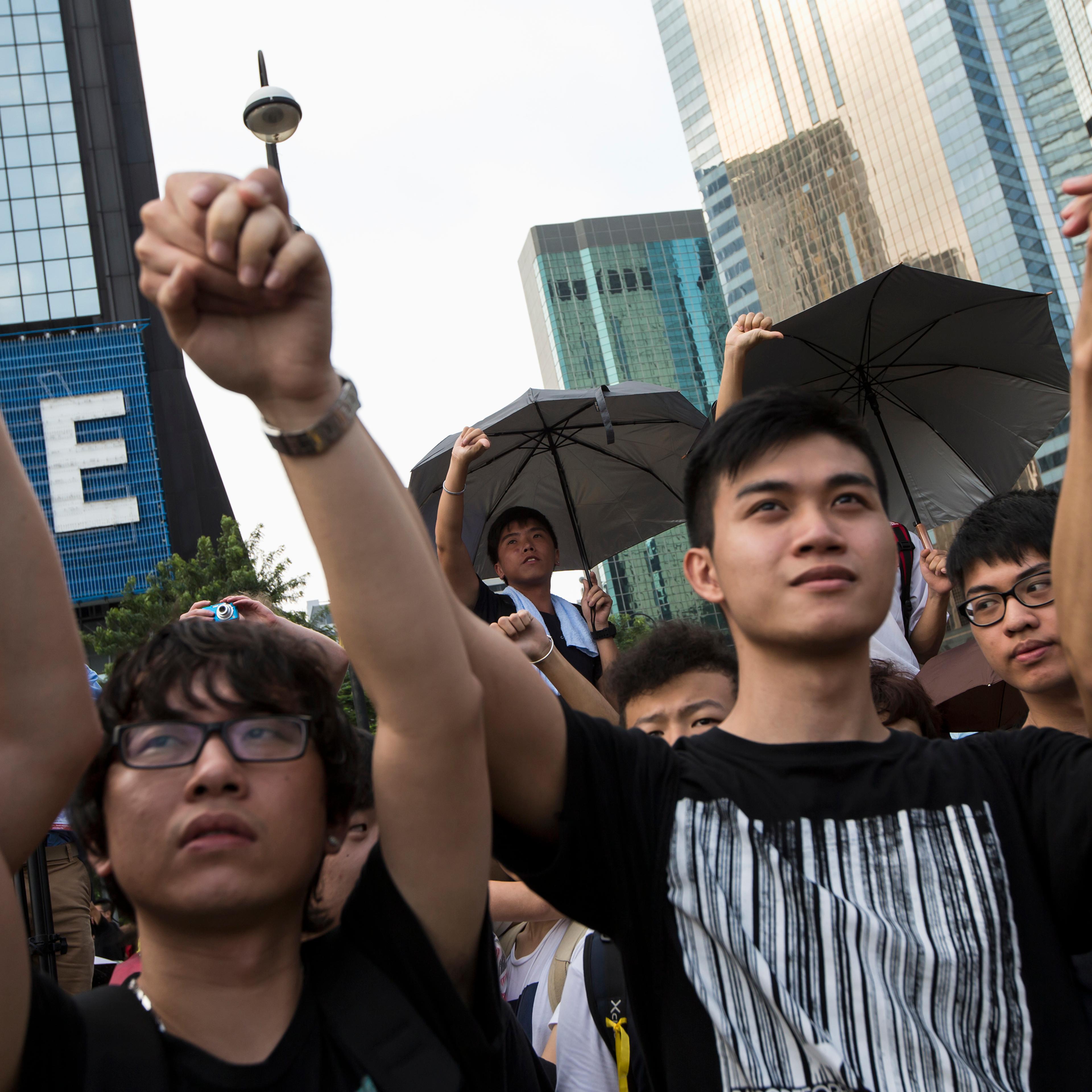 Student protesters gesture outside the Golden Bauhinia Square, venue of the official flag-raising ceremony for celebrations of China's National Day in Hong Kong