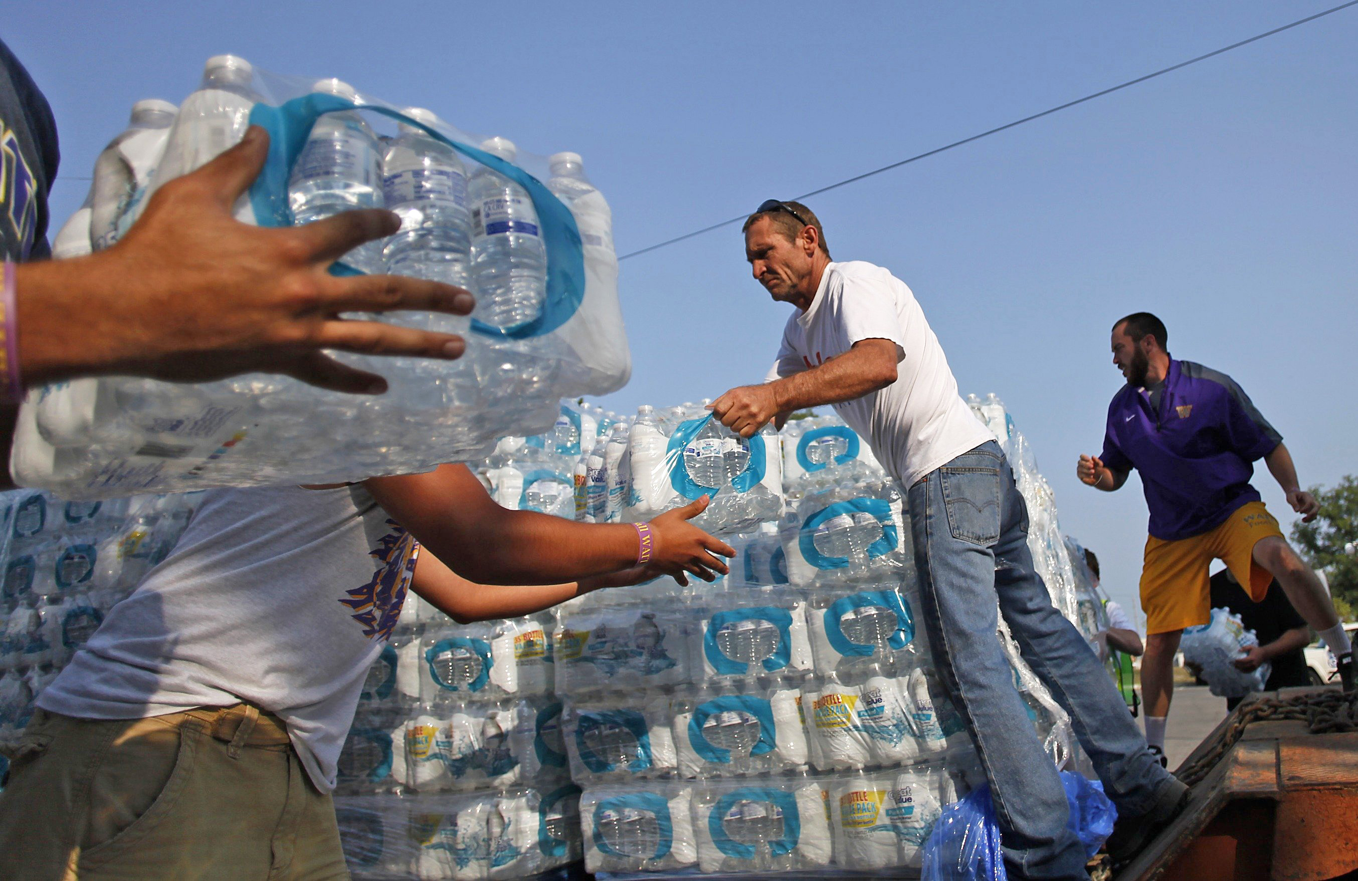 Volunteers unload drinking water from a truck outside Waite High School in Toledo