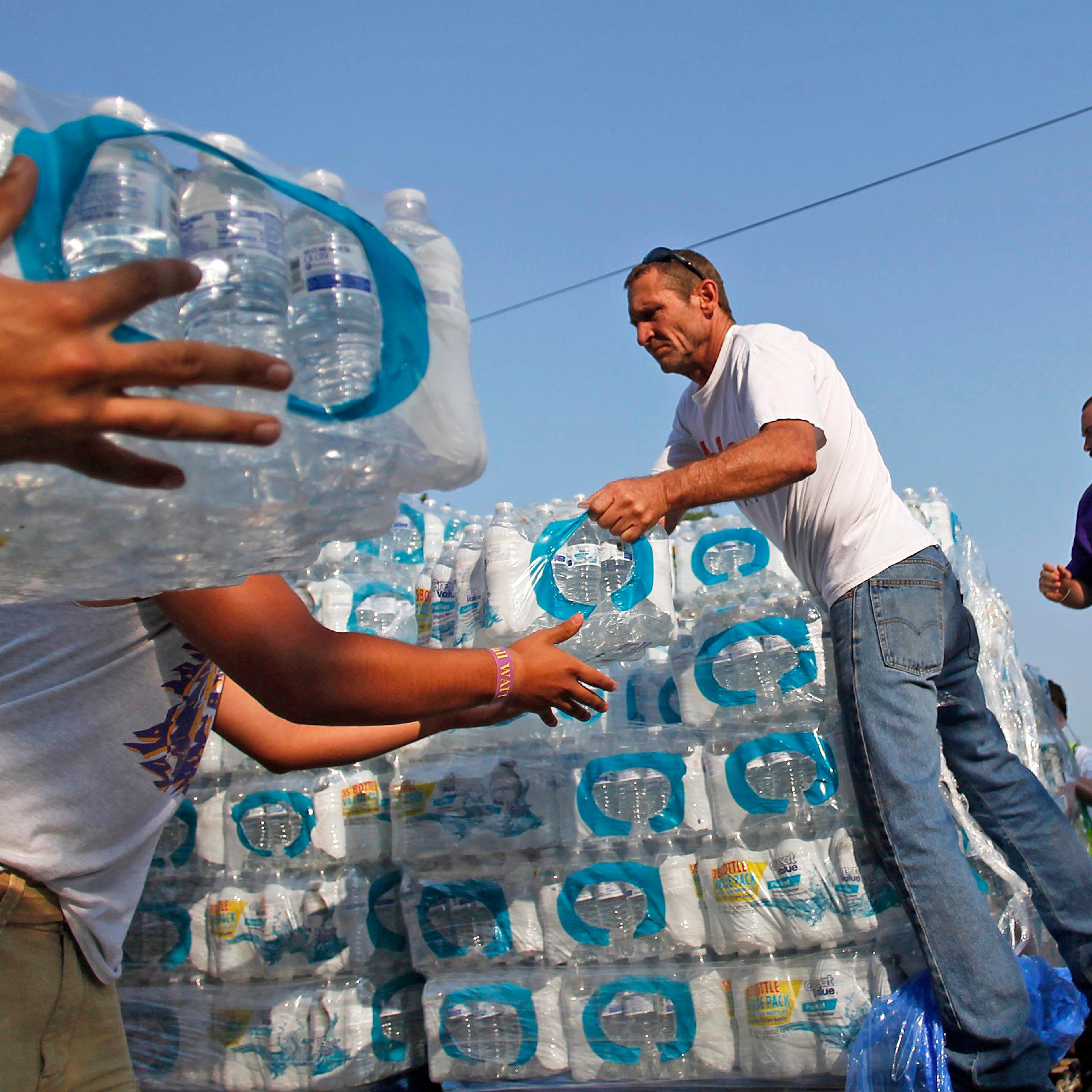 Volunteers unload drinking water from a truck outside Waite High School in Toledo