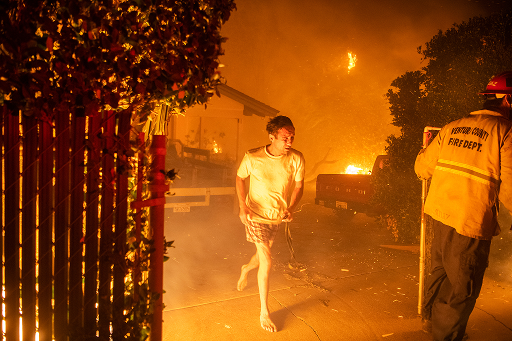 A resident flees his home in Thousand Oaks, Calif., on Nov. 9 with only the clothes on his back. Wildfires erupted in Northern and Southern California in early November, forcing an estimated 160,000 to evacuate.