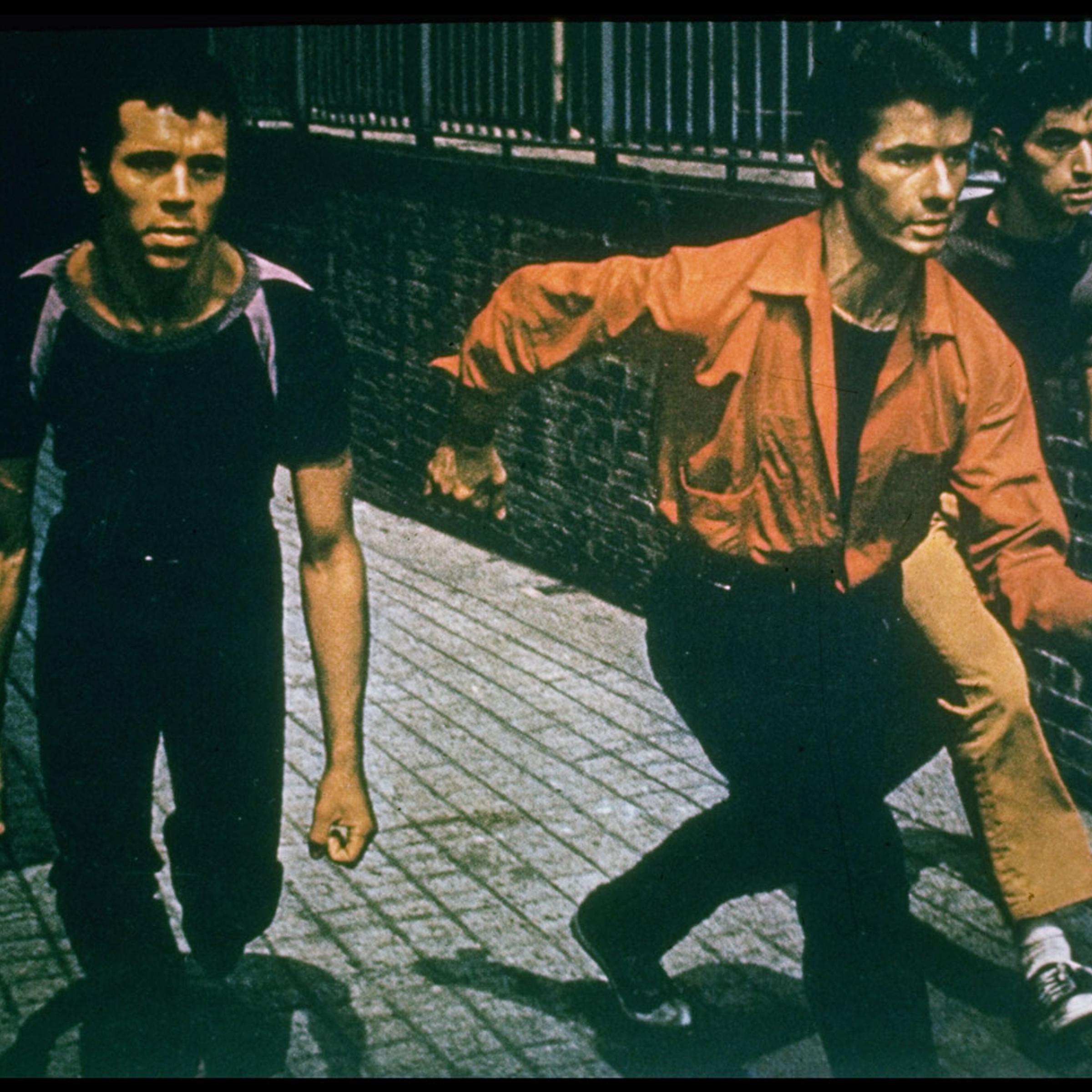 Bernardo (George Chakiris, center) leads gang, the Sharks, in a finger-snapping, crouching invasion of the turf of their rivals, the Jets.