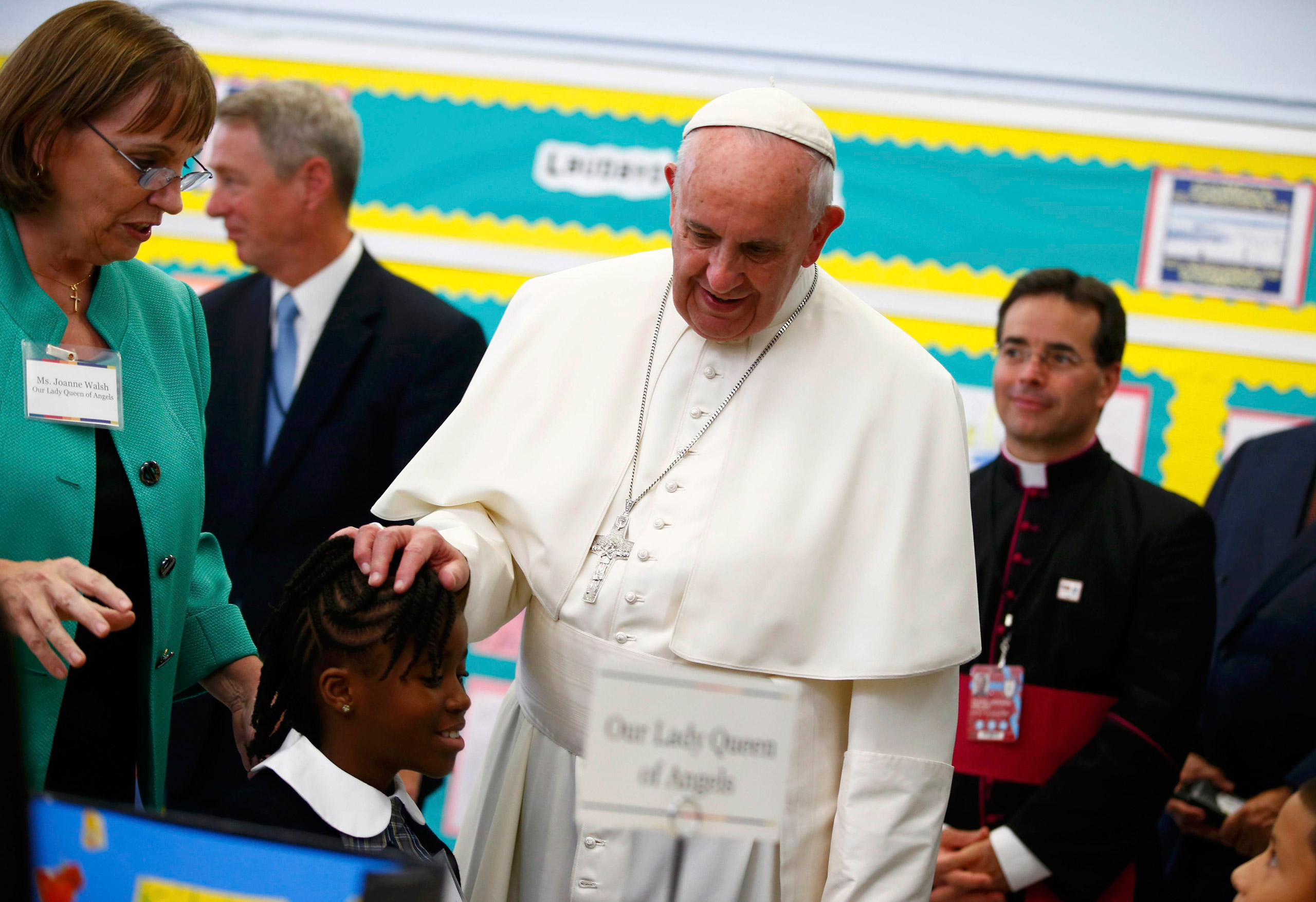 Pope Francis touches a student's head as he visits Our Lady Queen of Angels School in East Harlem in New York