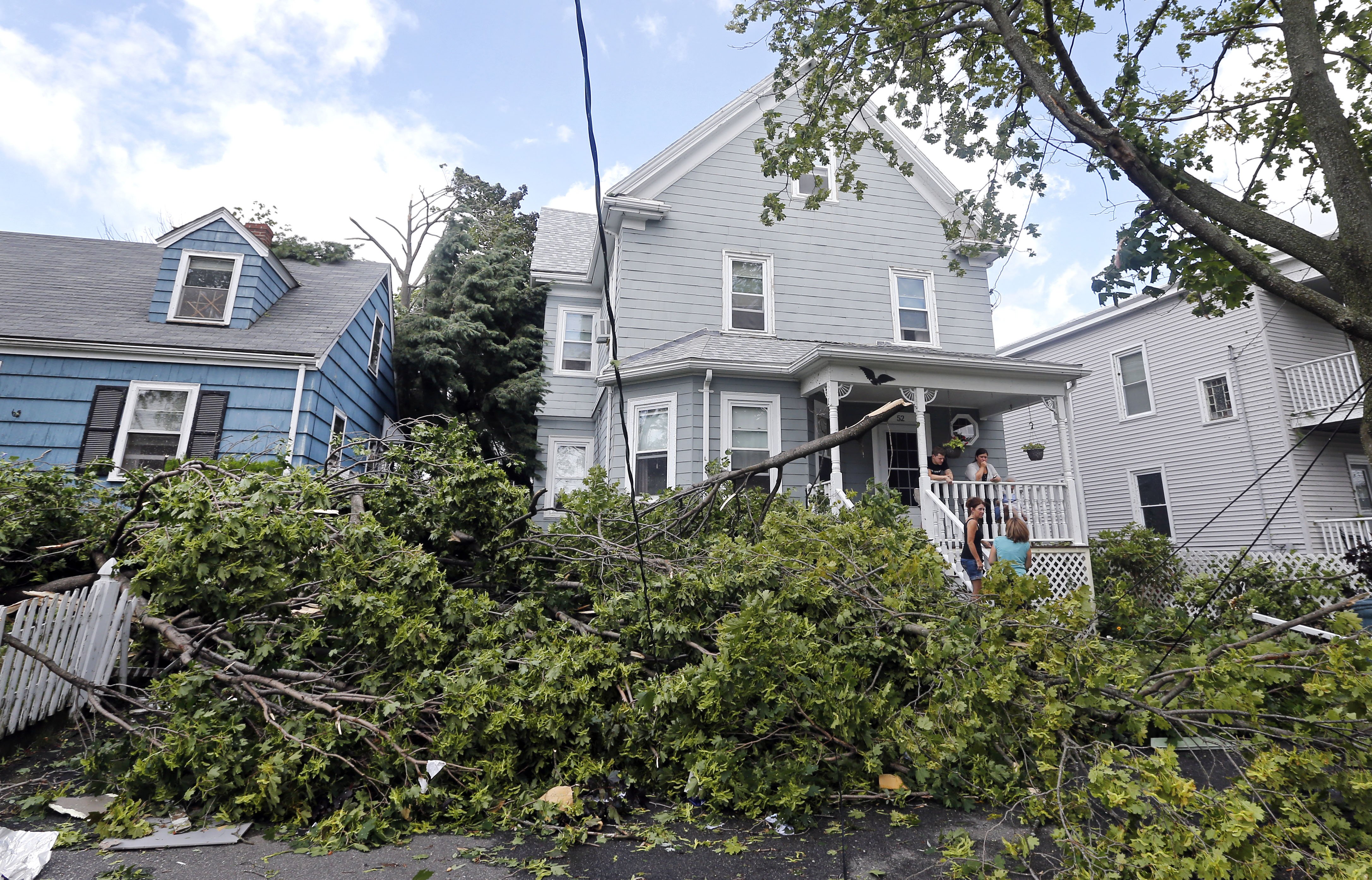 Downed trees and power lines lay in front of homes in Revere, Mass., on July 28, 2014 after a tornado touched down.