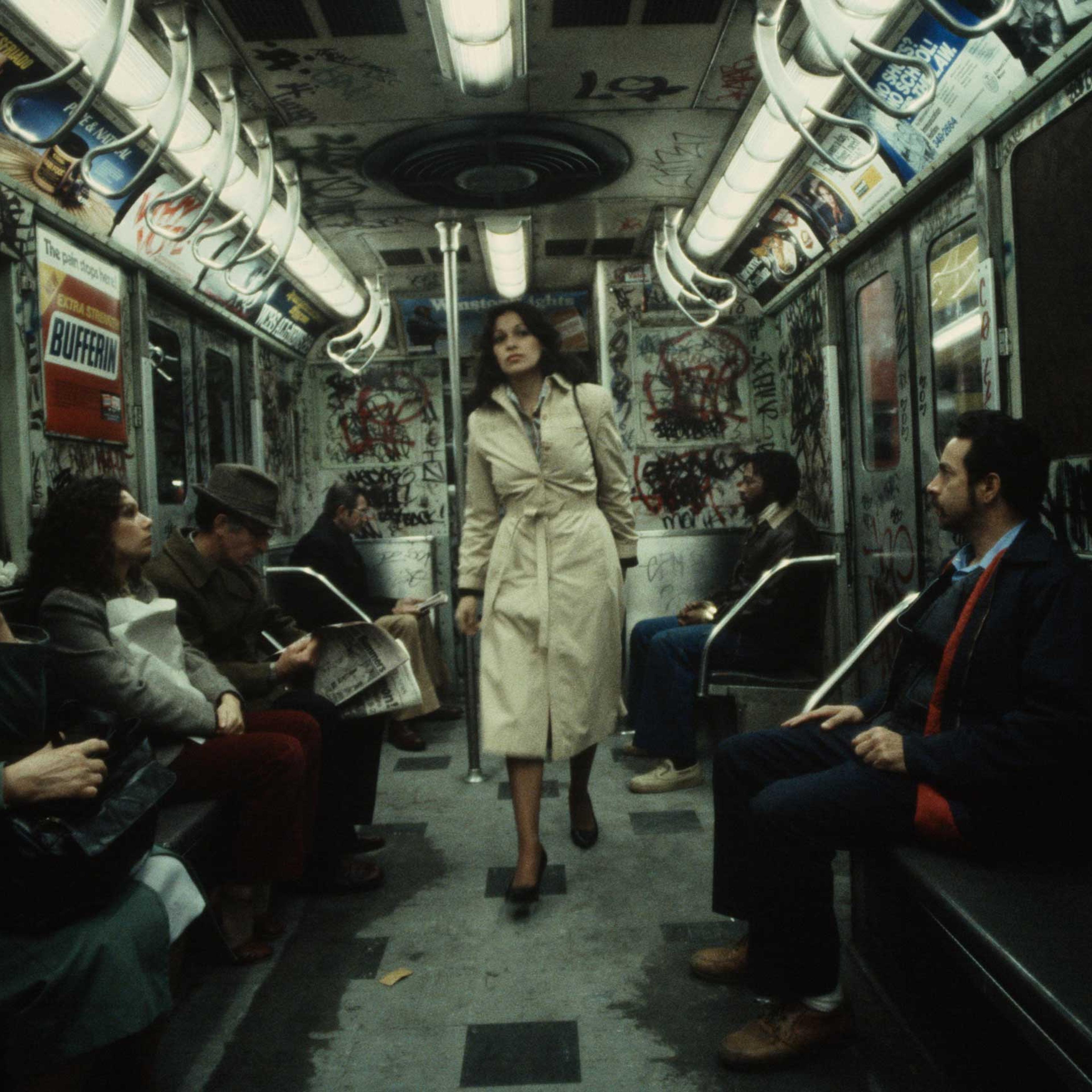 The following previously unpublished photos were taken by Christopher Morris in 1981: A woman walks through a heavily graffitied subway car, 1981.