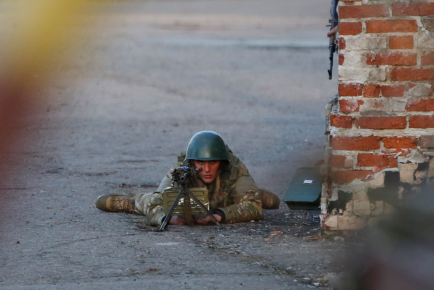 An Ukrainian soldier aims his weapon at pro-Russia protesters gathered in front of an Ukrainian airbase in Kramatorsk, in eastern Ukraine, April 15, 2014.