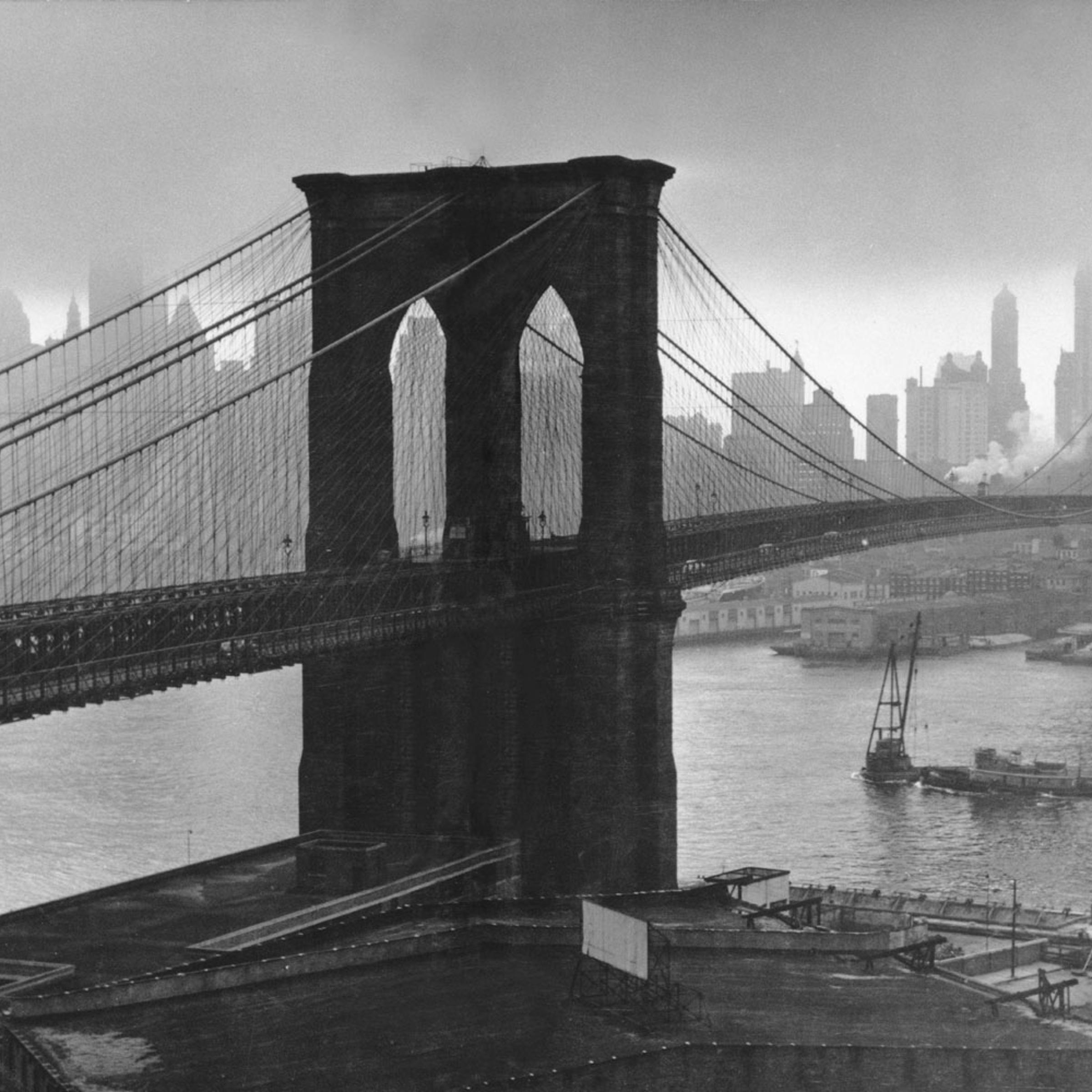 Stormy sky hovers over the Brooklyn Bridge and the ghostly skyscrapers of Manhattan's financial district in March 1946.