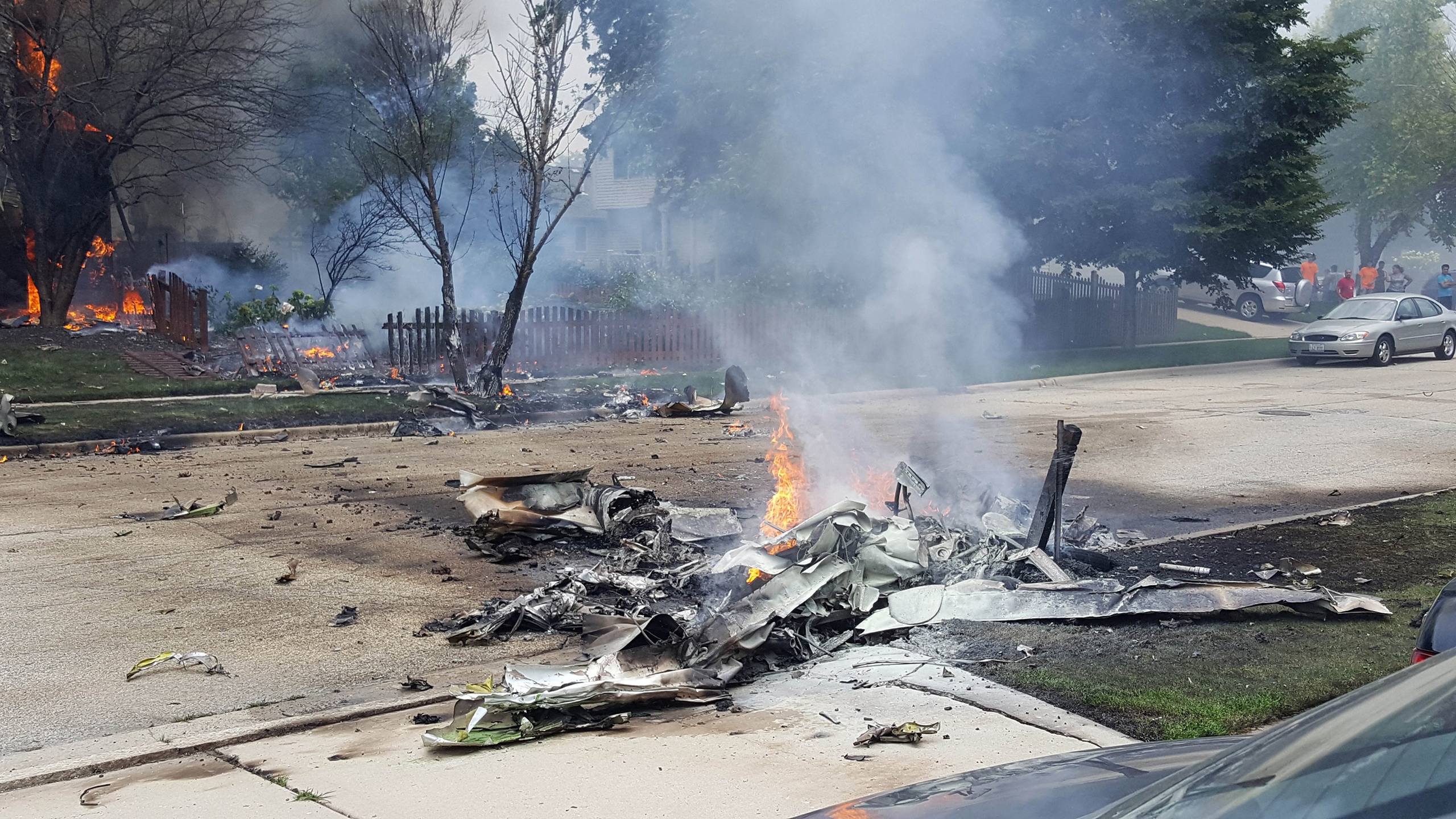 Wrekage from a plane crash burns near Bedord Drive and Pembrook Court in Plainfield, Ill. on July 21, 2016.