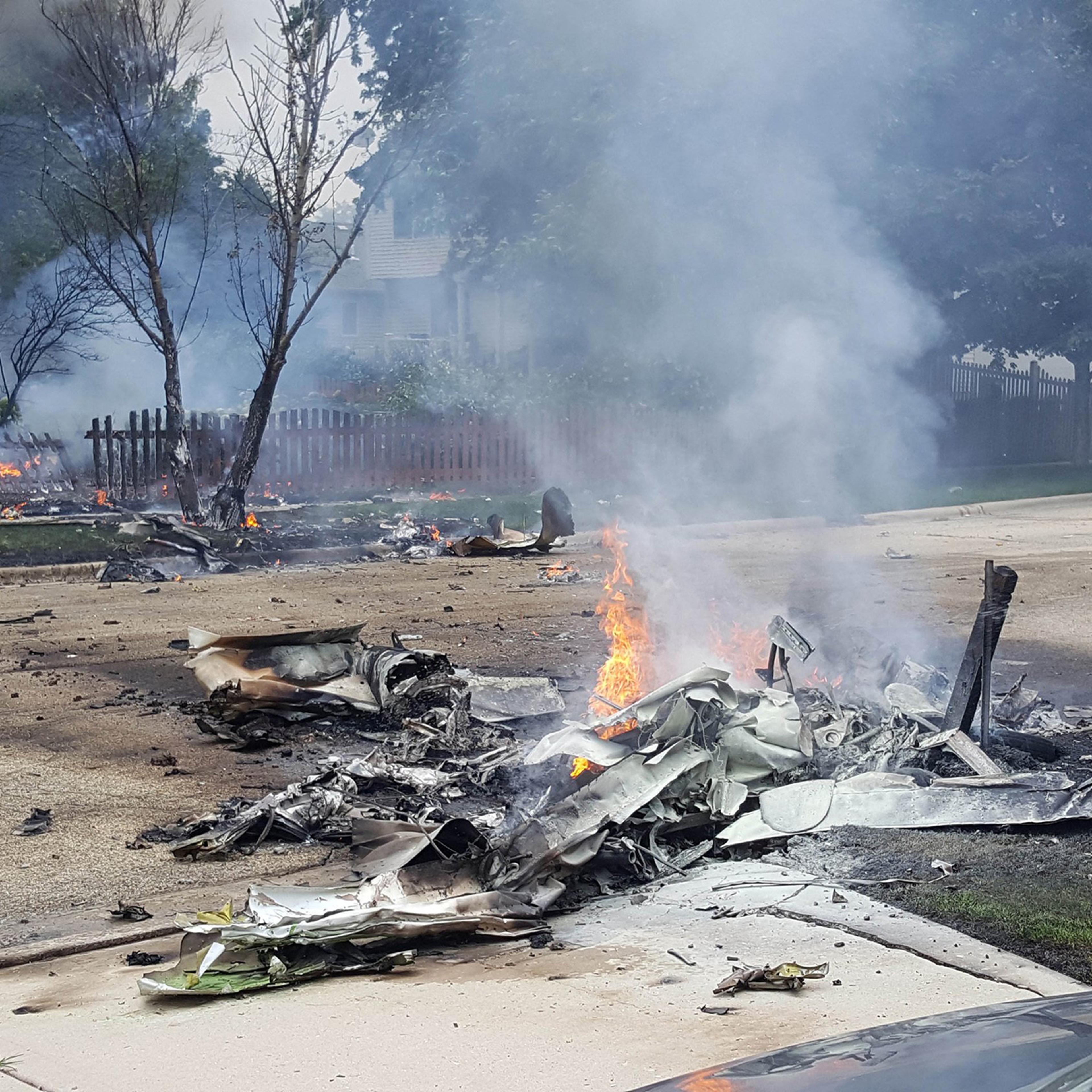 Wrekage from a plane crash burns near Bedord Drive and Pembrook Court in Plainfield, Ill. on July 21, 2016.