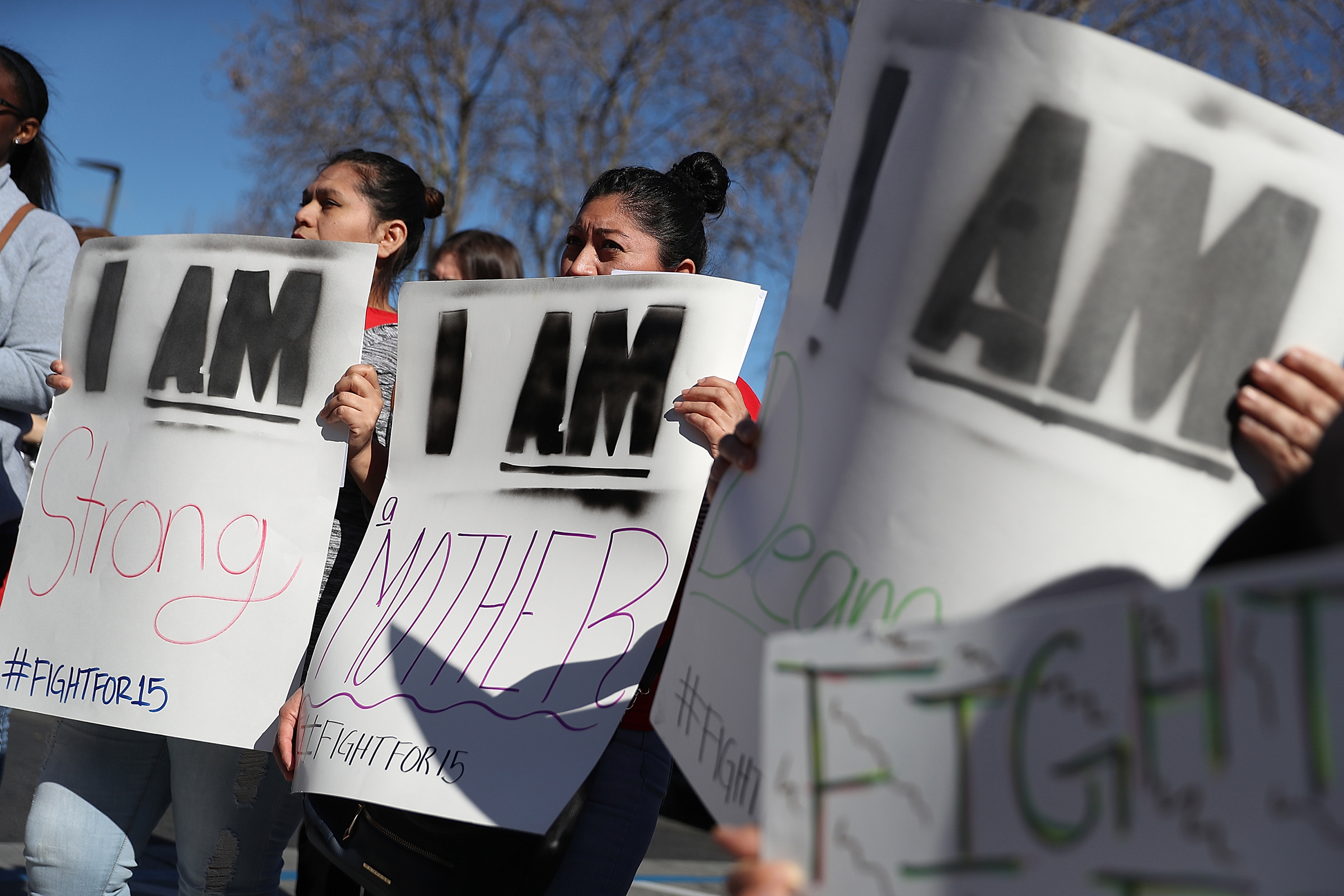 Fast food workers and union members carry signs as they stage a protest outside of a McDonald's restaurant in Oakland, Calif., on Feb. 12, 2018, the 50th anniversary of the historic Memphis Sanitation Strike that was led by Dr. Martin Luther King Jr.
