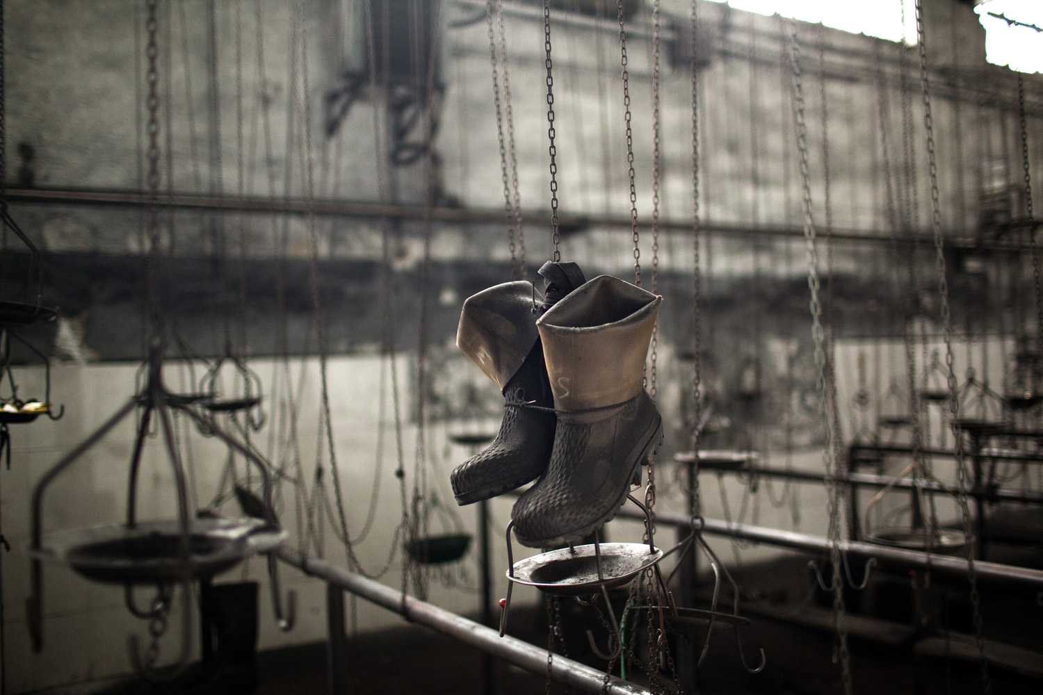 June 18, 2012. Boots hang in a changing room in the partially abandoned and closed Santiago mine, as a result of the coal crisis near Mieres, Oviedo, Spain.
