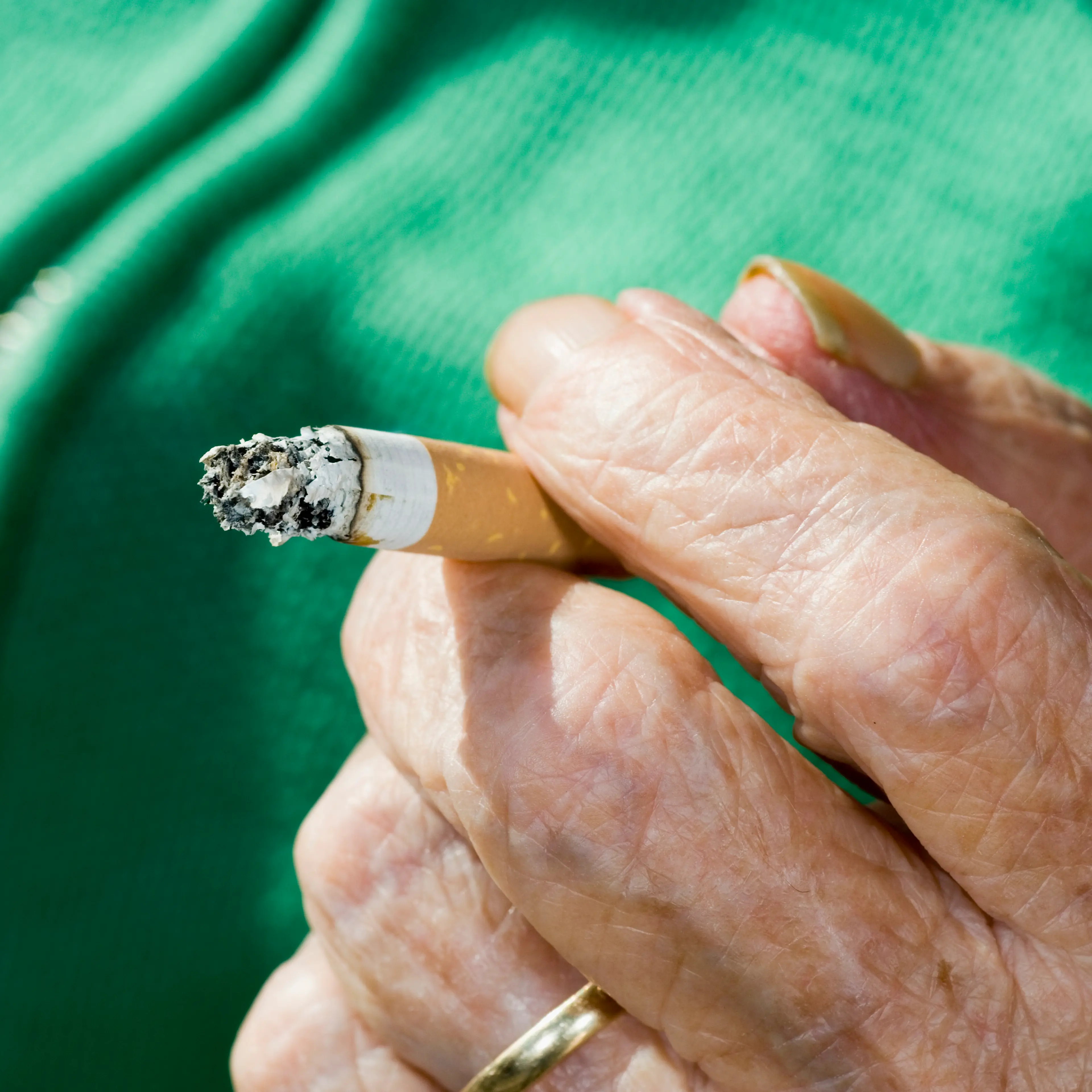 Elderly Hand Holding Cigarette Butt