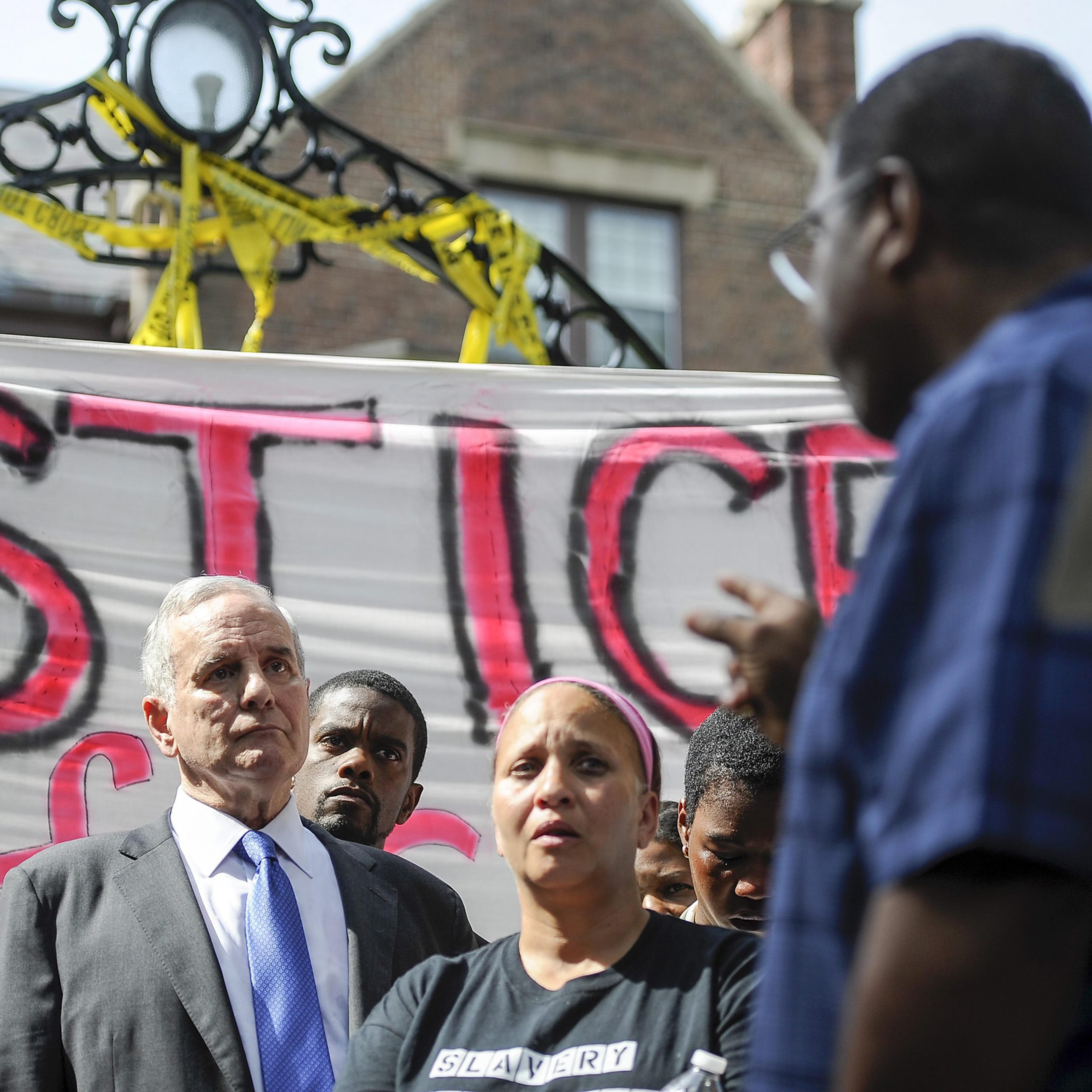 Brian Herron, Pastor of Zion Baptist Church in Minneapolis, turns from the podium to address Minnesota Governor Mark Dayton as he speaks about the police shooting of Philando Castile, during a news conference in front of the governors residence in St. Pa