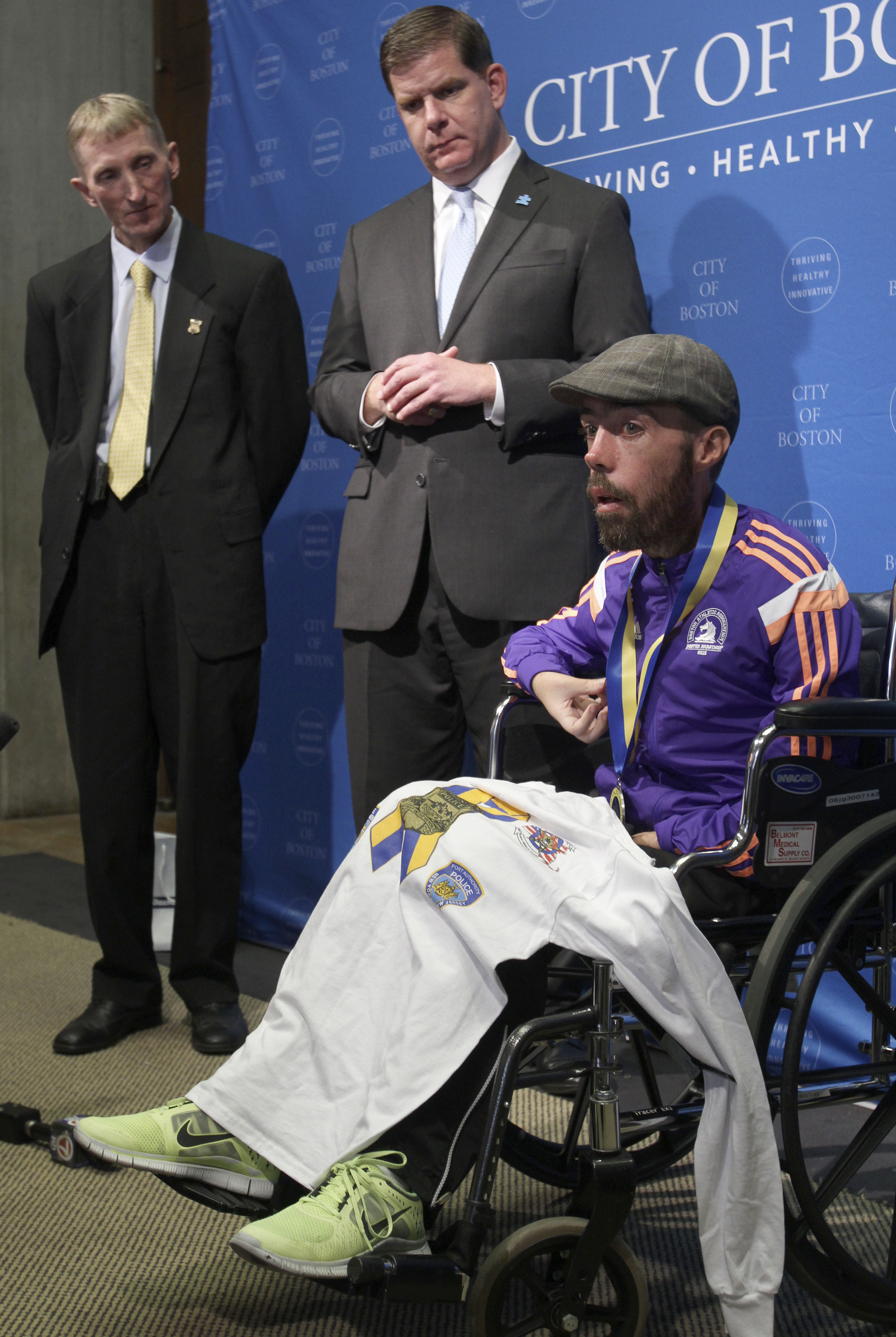 Boston Police Commissioner William Evans (L) and Mayor Marty Walsh (C) listen as Maickel Melamed, of Venezuela, speaks during a Boston Marathon ceremony in Boston on April 21, 2015.