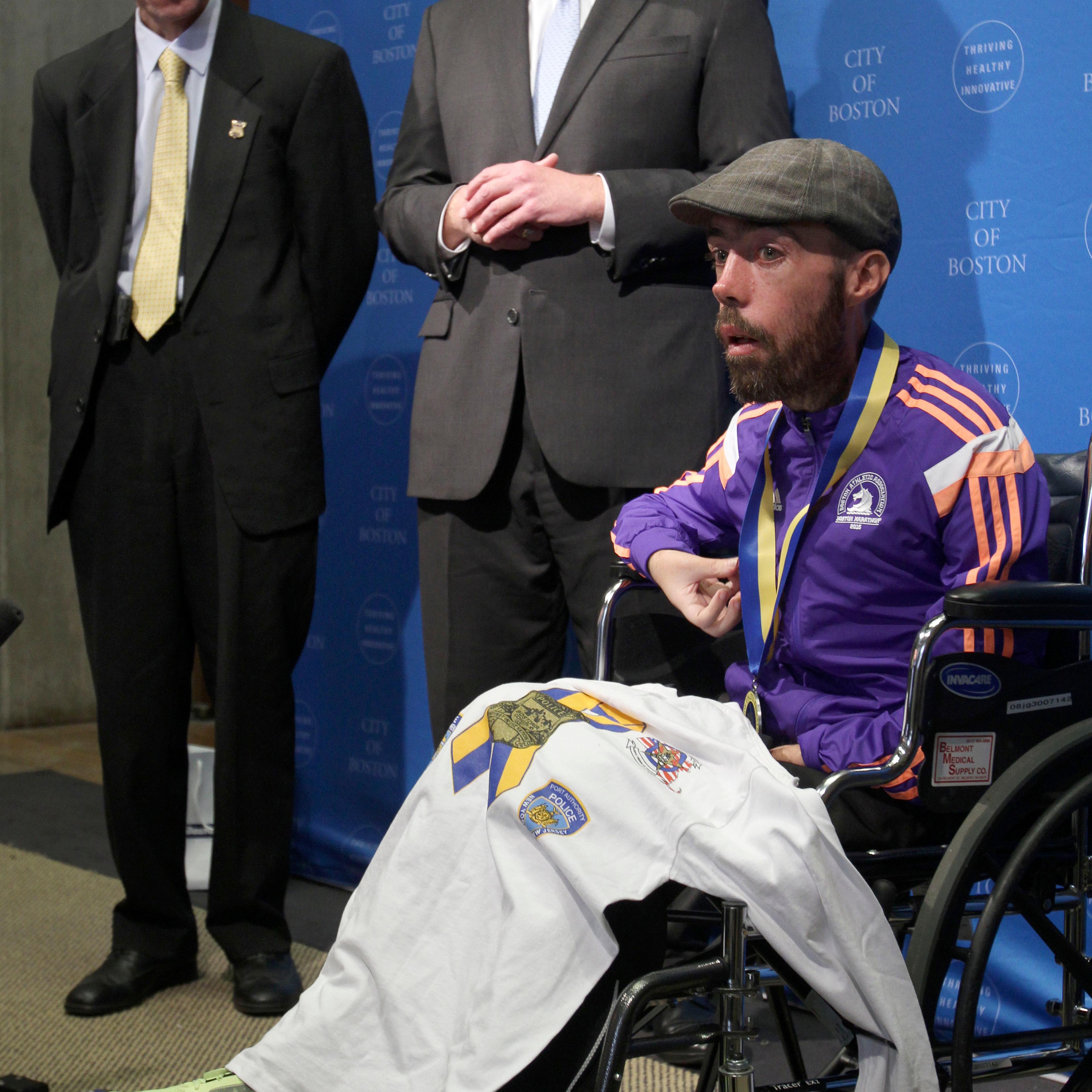 Boston Police Commissioner William Evans (L) and Mayor Marty Walsh (C) listen as Maickel Melamed, of Venezuela, speaks during a Boston Marathon ceremony in Boston on April 21, 2015.