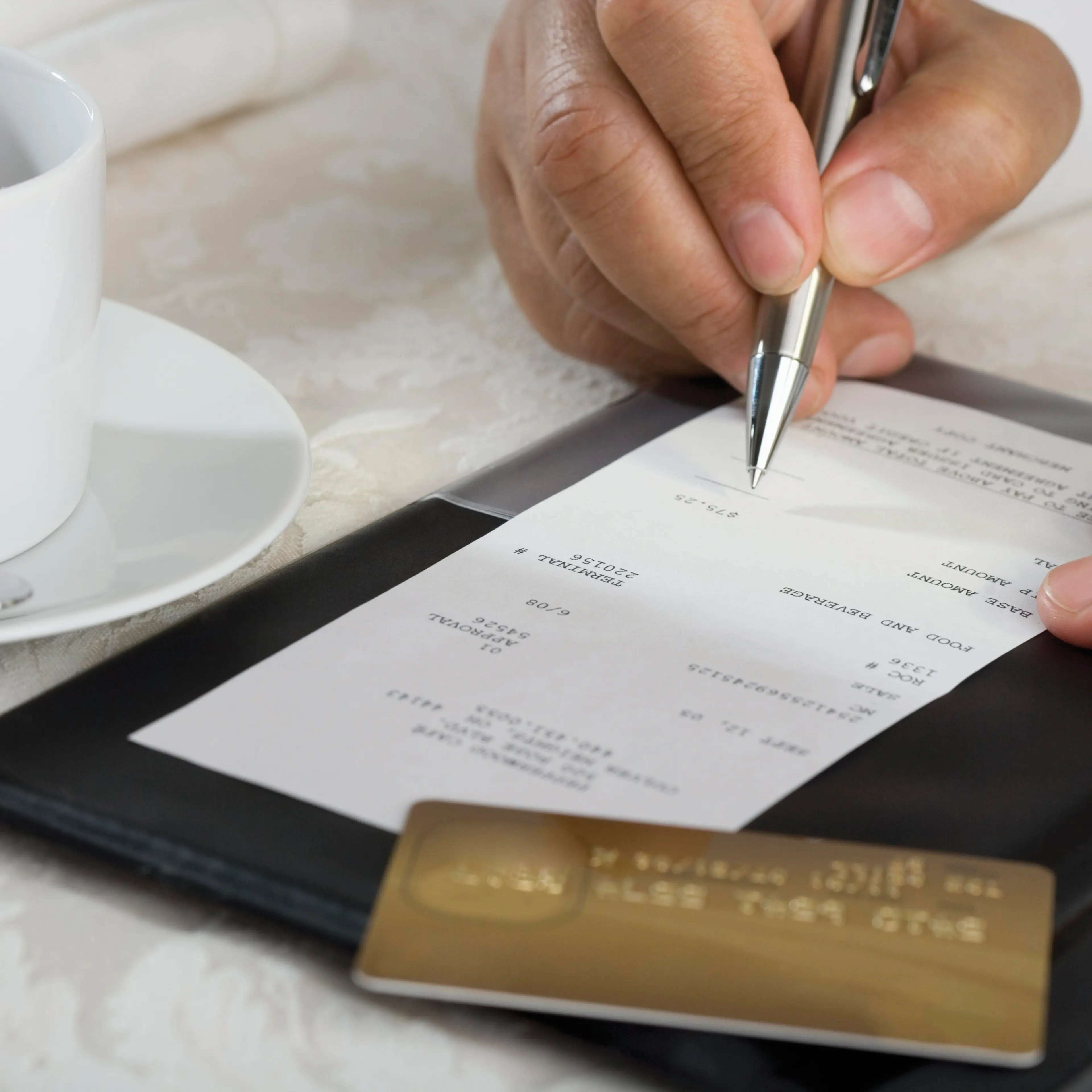 Man signing credit card bill at restaurant
