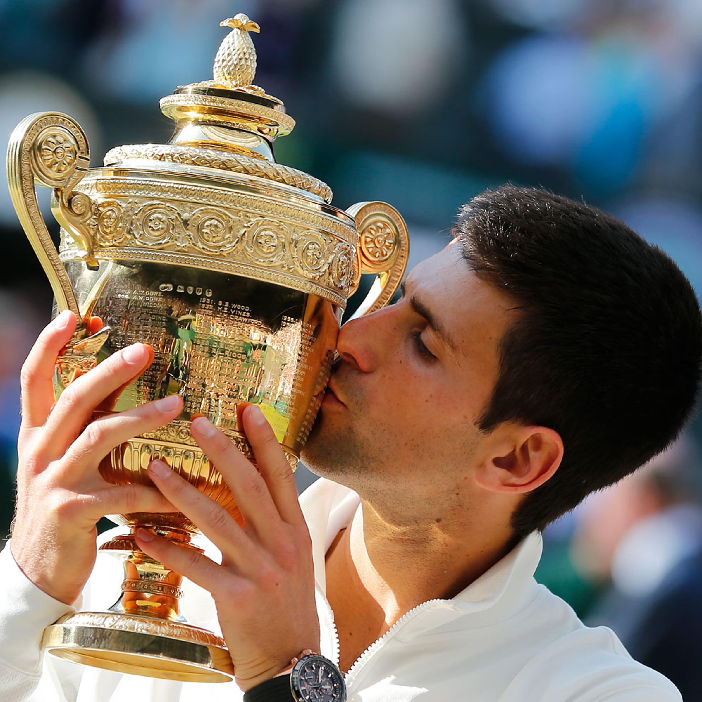Novak Djokovic kisses the trophy after defeating Roger Federer in the men's singles final at the All England Lawn Tennis Championships in Wimbledon, London, on July 6, 2014