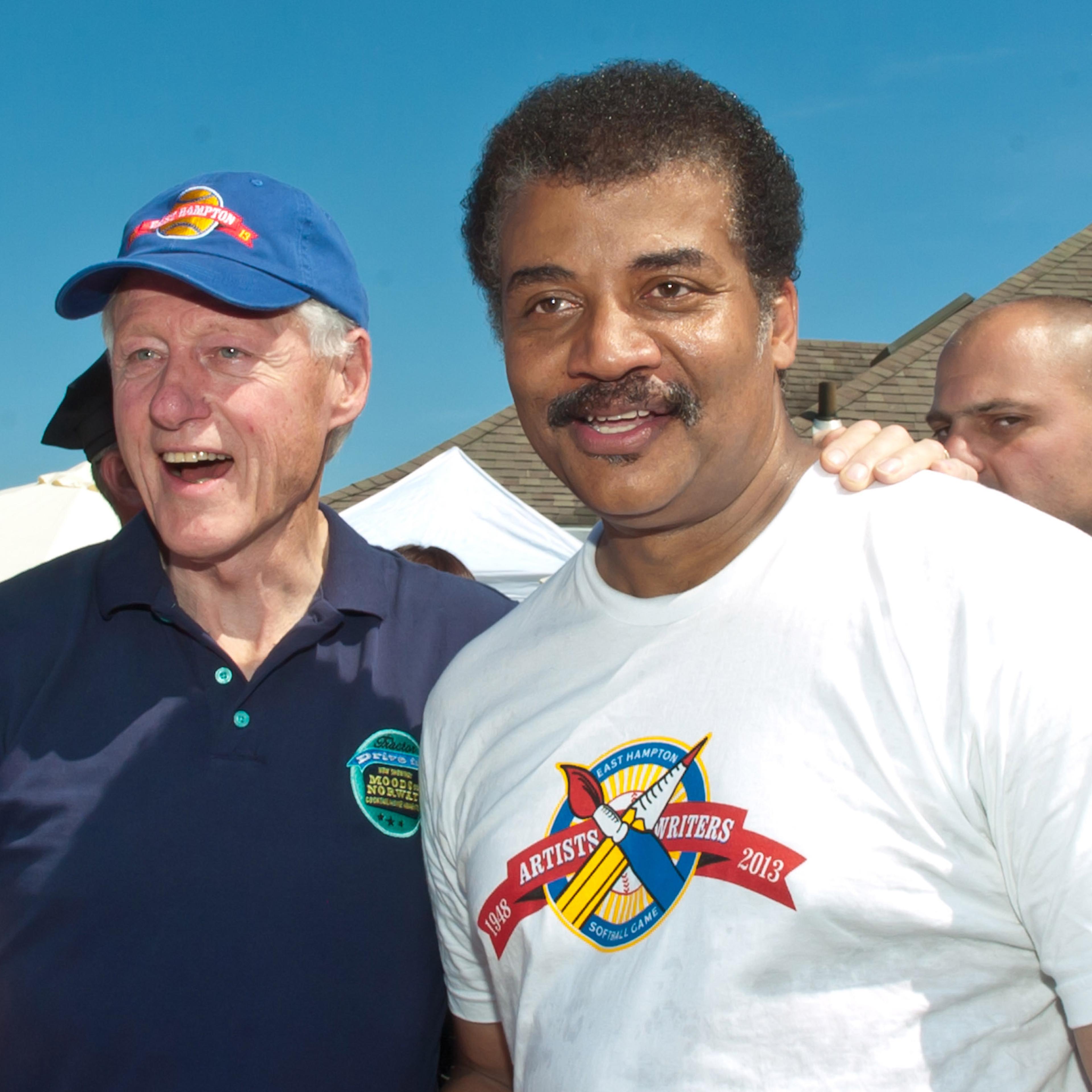 Former President Bill Clinton and Dr. Neil deGrasse Tyson attend the 65th Anniversary Artists & Writers Celebrity Softball Game at Herrick Park on Aug. 17, 2013 in East Hampton, New York.