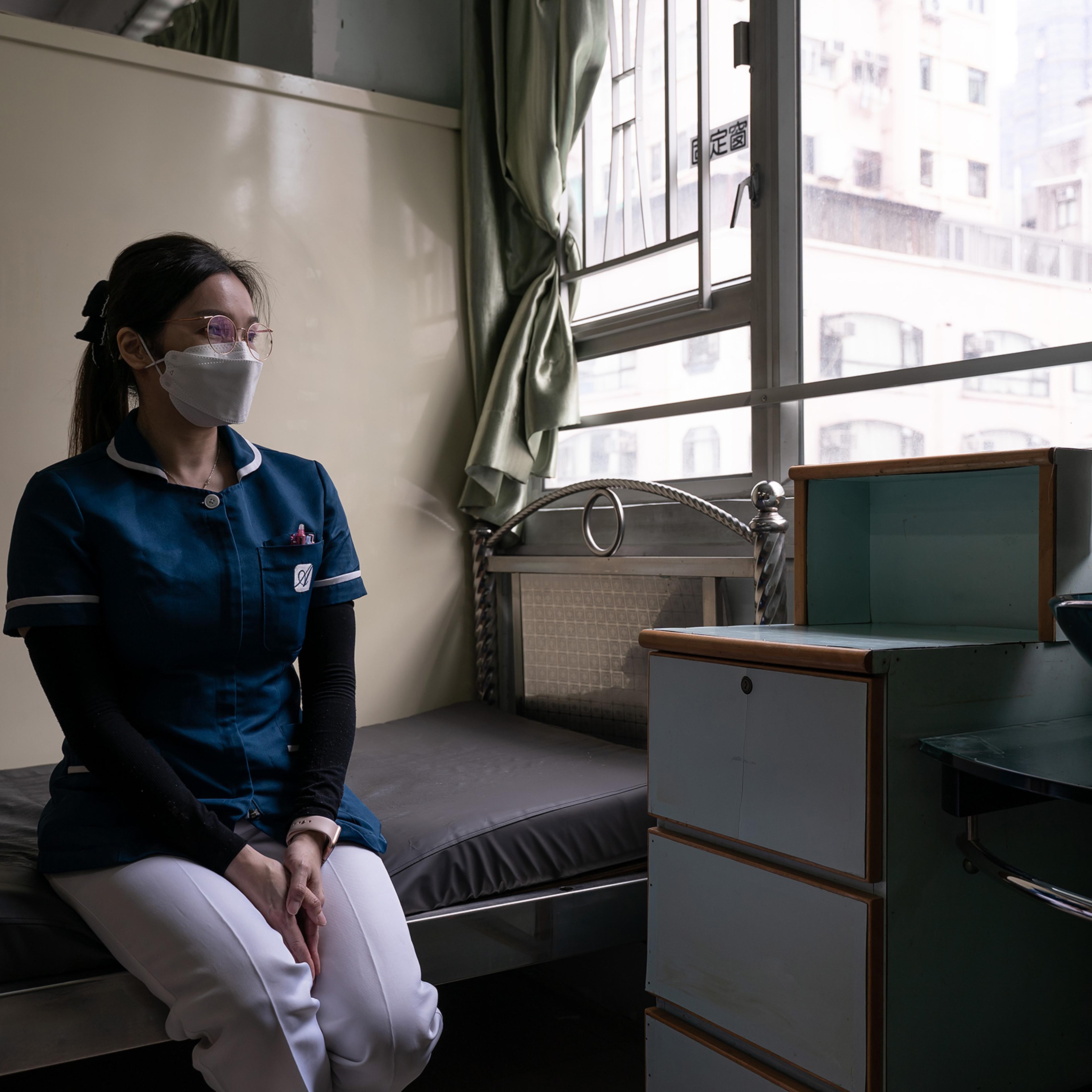 Wong Wing-yan, a nurse at Kei Tak (Tai Hang) Home For the Aged, sits in her godmother’s living cubicle, who has recently passed away due to the fifth wave of pandemic, in Yuen Long district in Hong Kong on May 6, 2022.