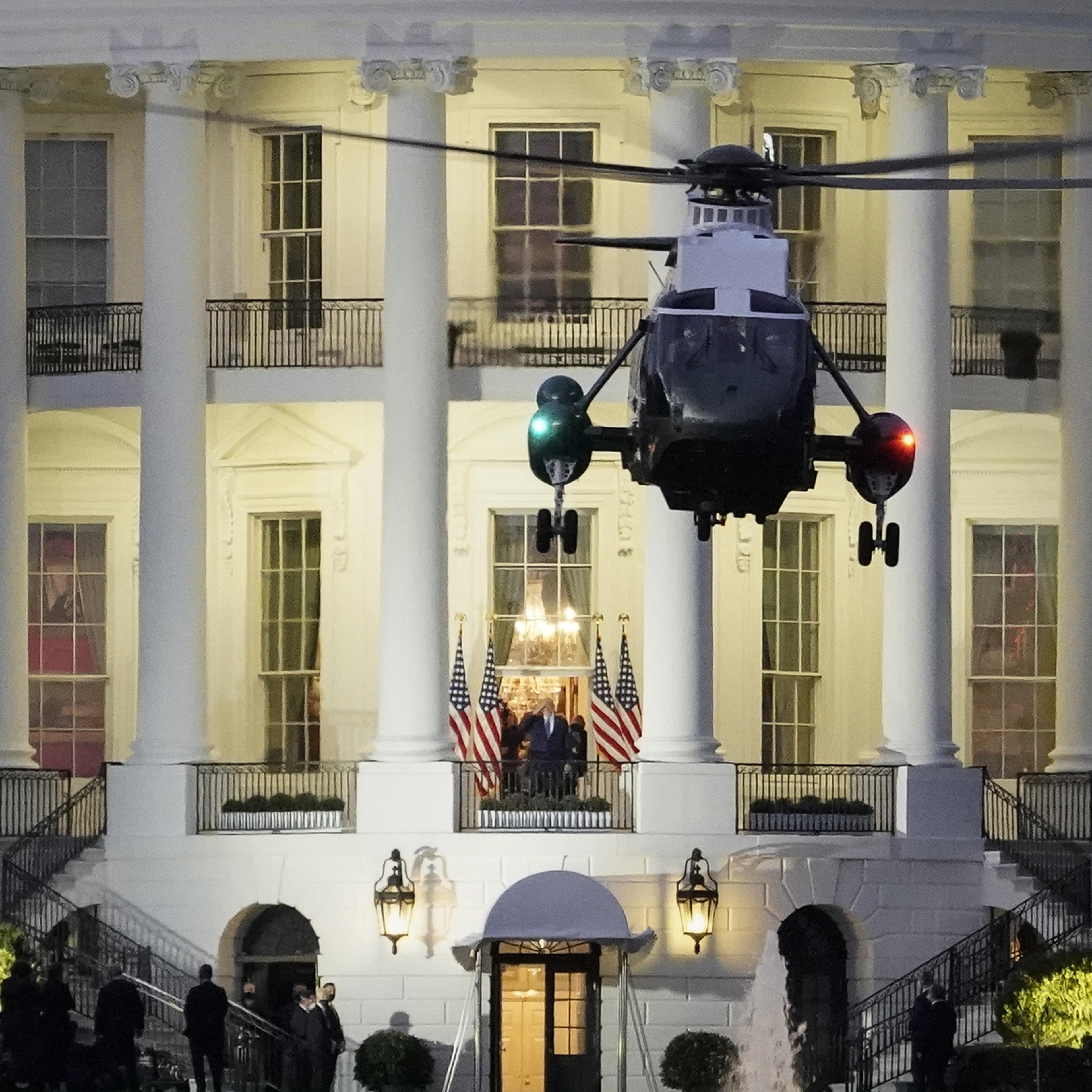U.S. President Donald Trump stands on the Blue Room Balcony as Marine One takes off from the South Lawn of the White House on Oct. 5