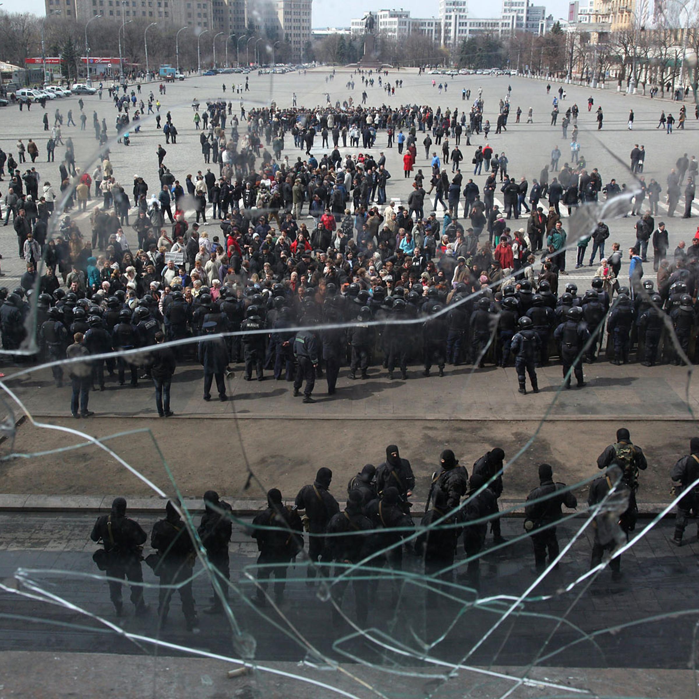 Pro-Russian protesters gather in front of Ukrainian police officers in font of the Kharkiv regional state administration building on April 8, 2014.