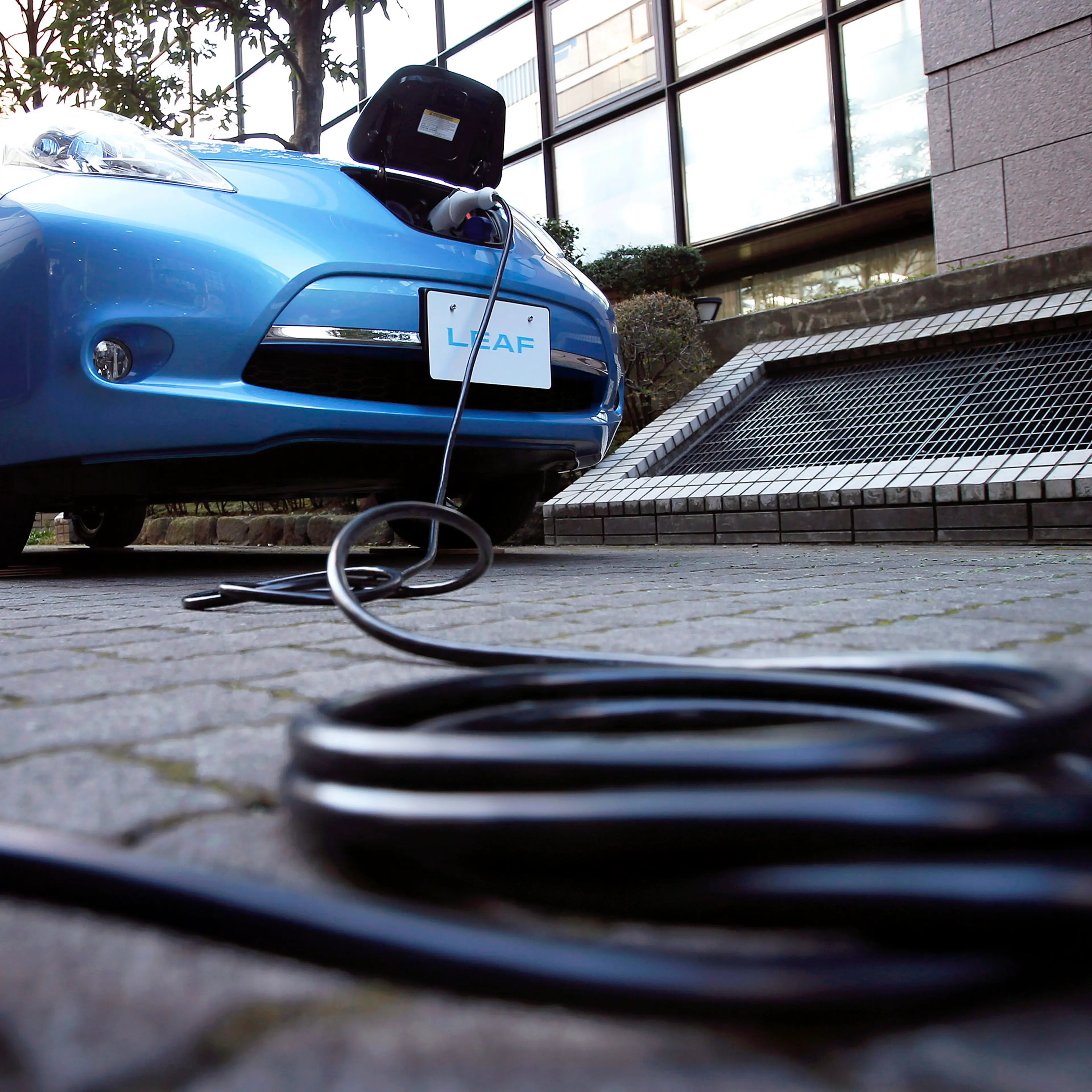 An electric charging cable is seen connected to the updated Nissan Leaf vehicle during a news conference in Japan, Tokyo, on Tuesday, Nov. 20, 2012.