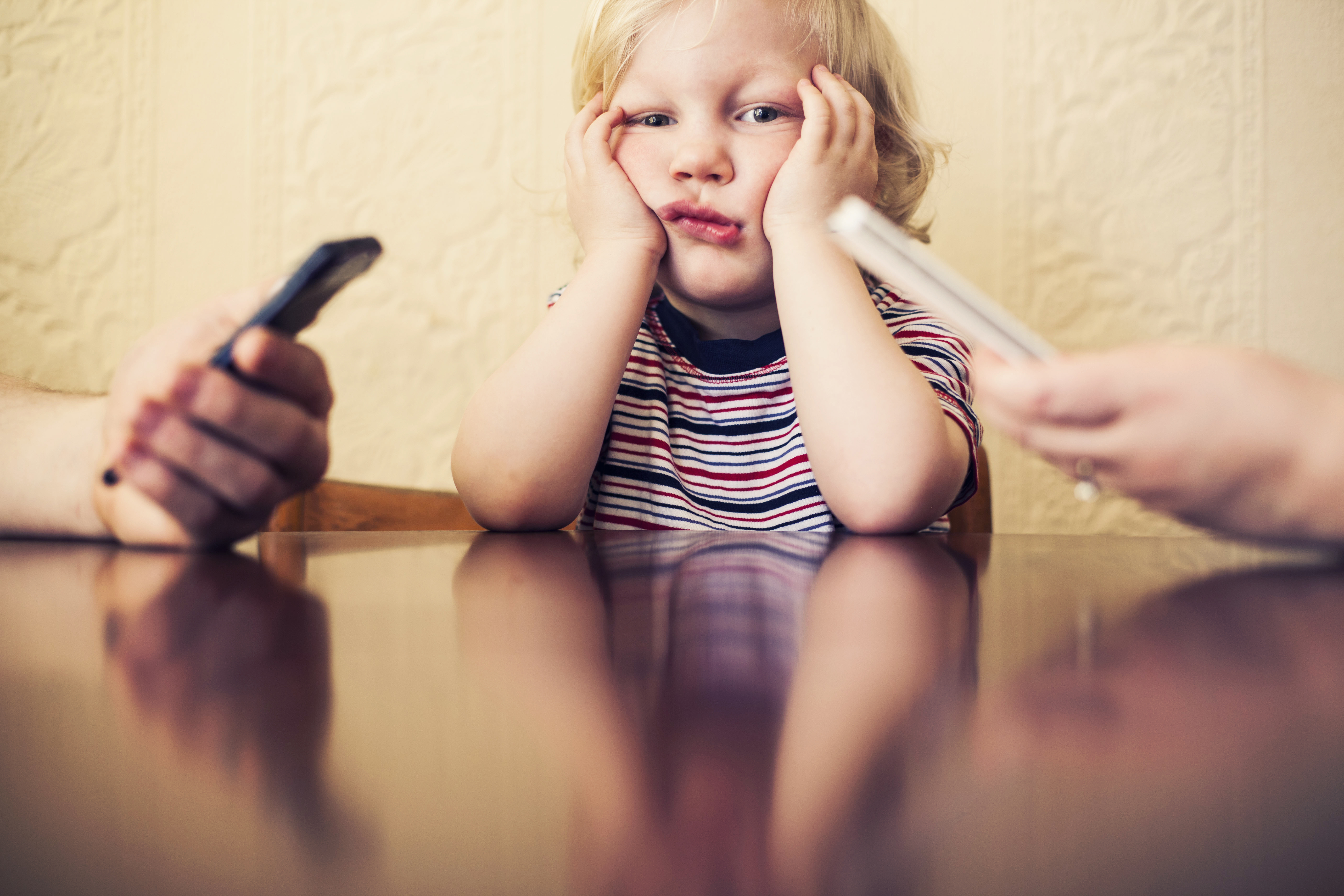 Boy next to adults with smart phones