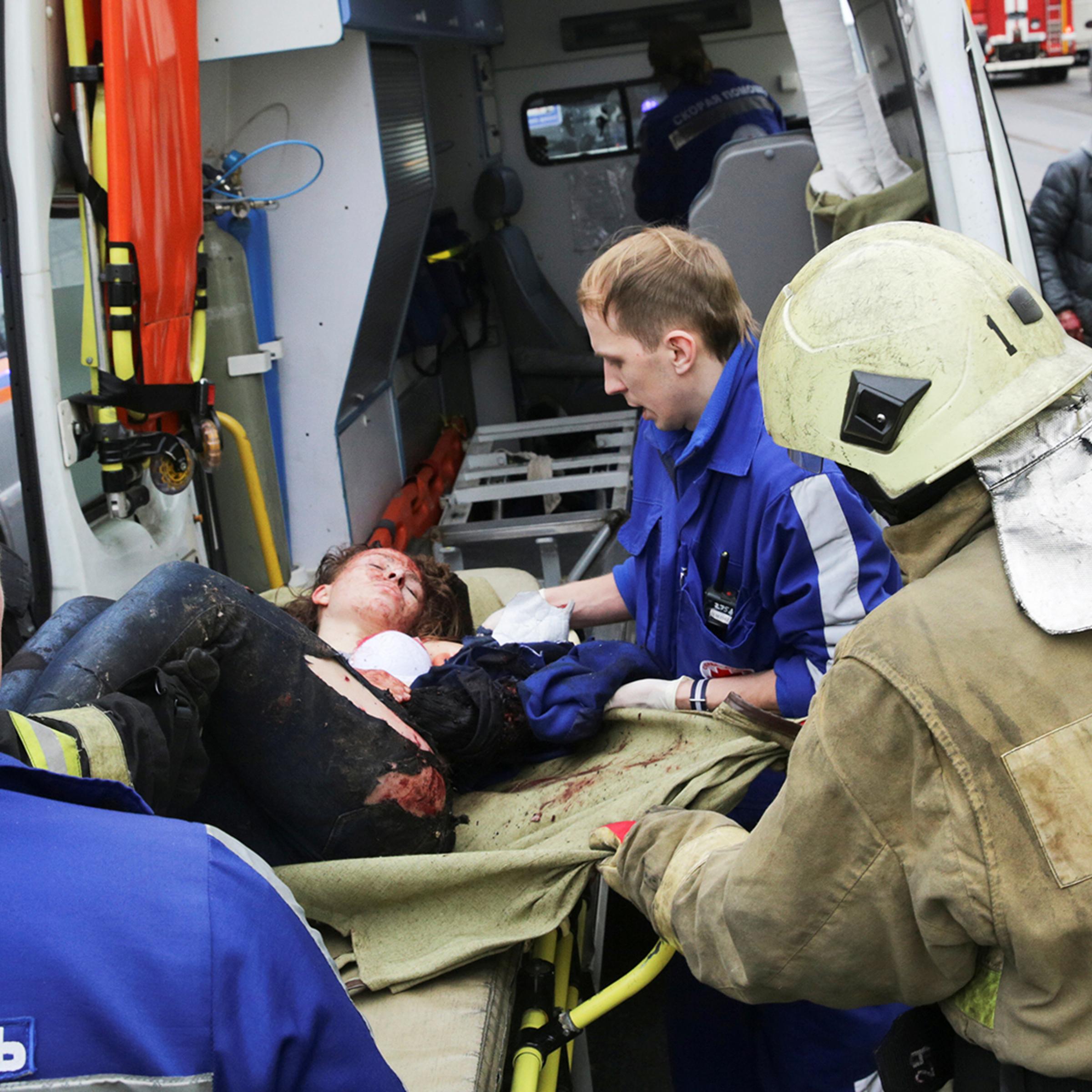 An injured person is helped by emergency services outside Sennaya Ploshchad metro station following explosions in St. Petersburg