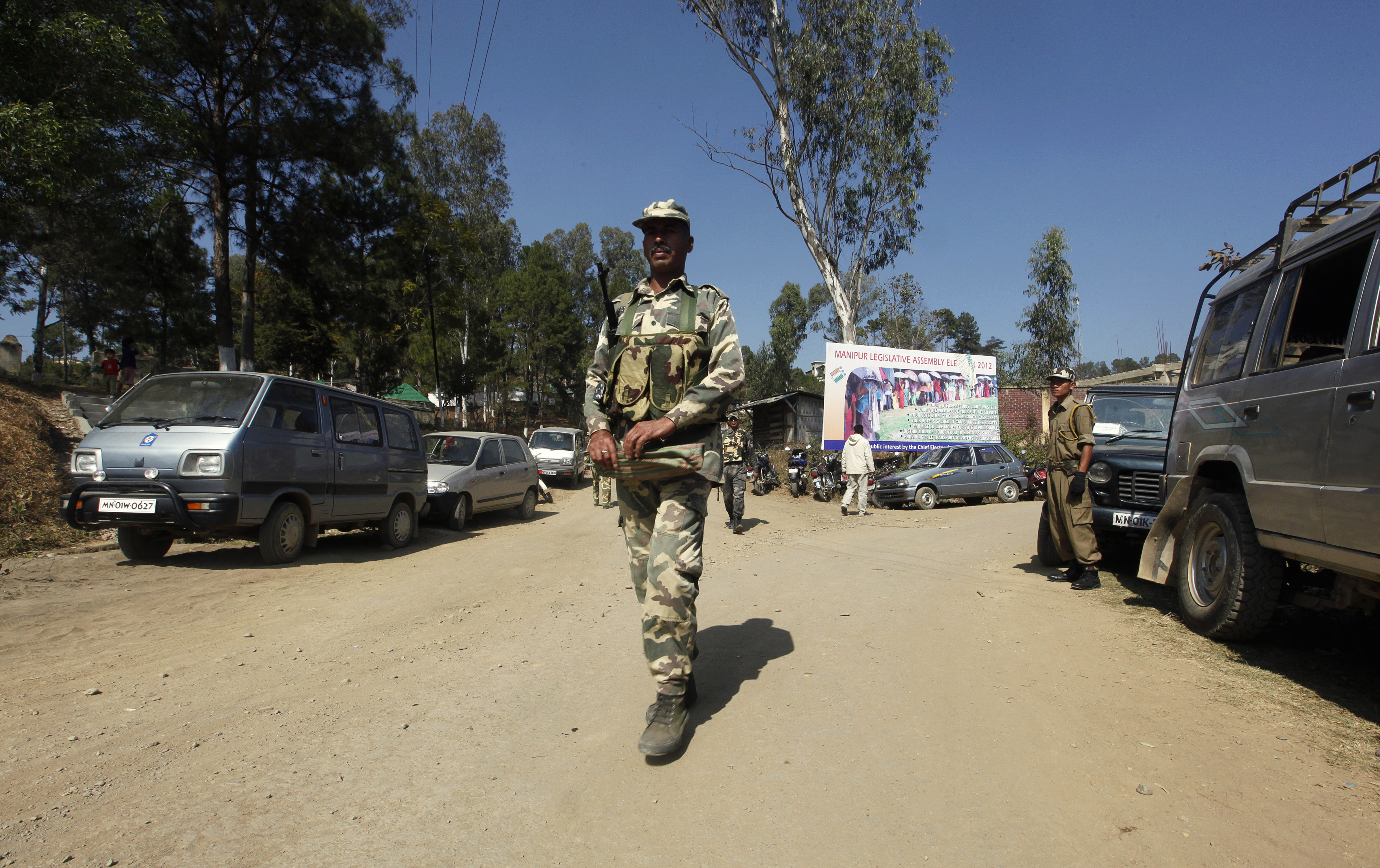 Security force personnel patrol road at village in Chandel district