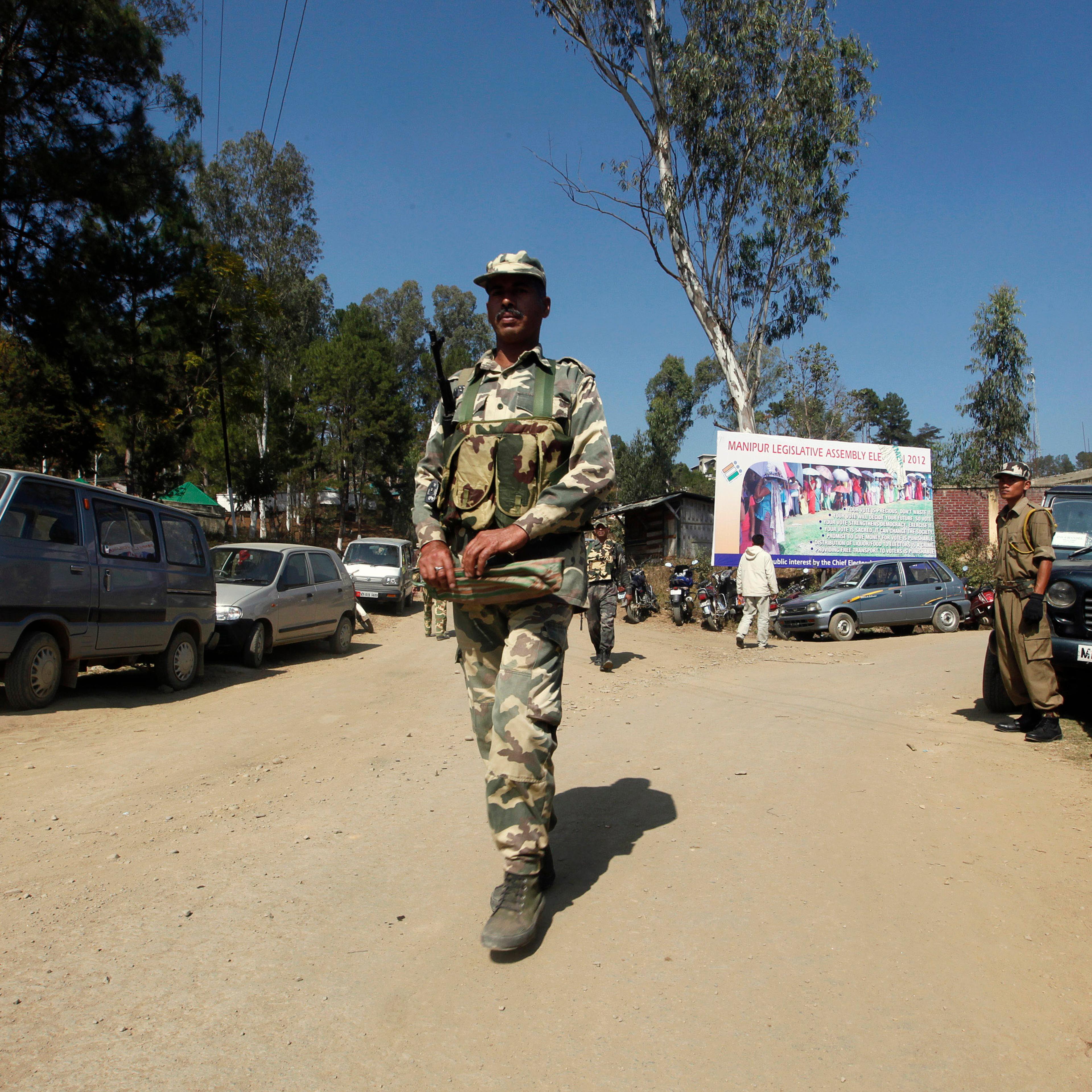 Security force personnel patrol road at village in Chandel district