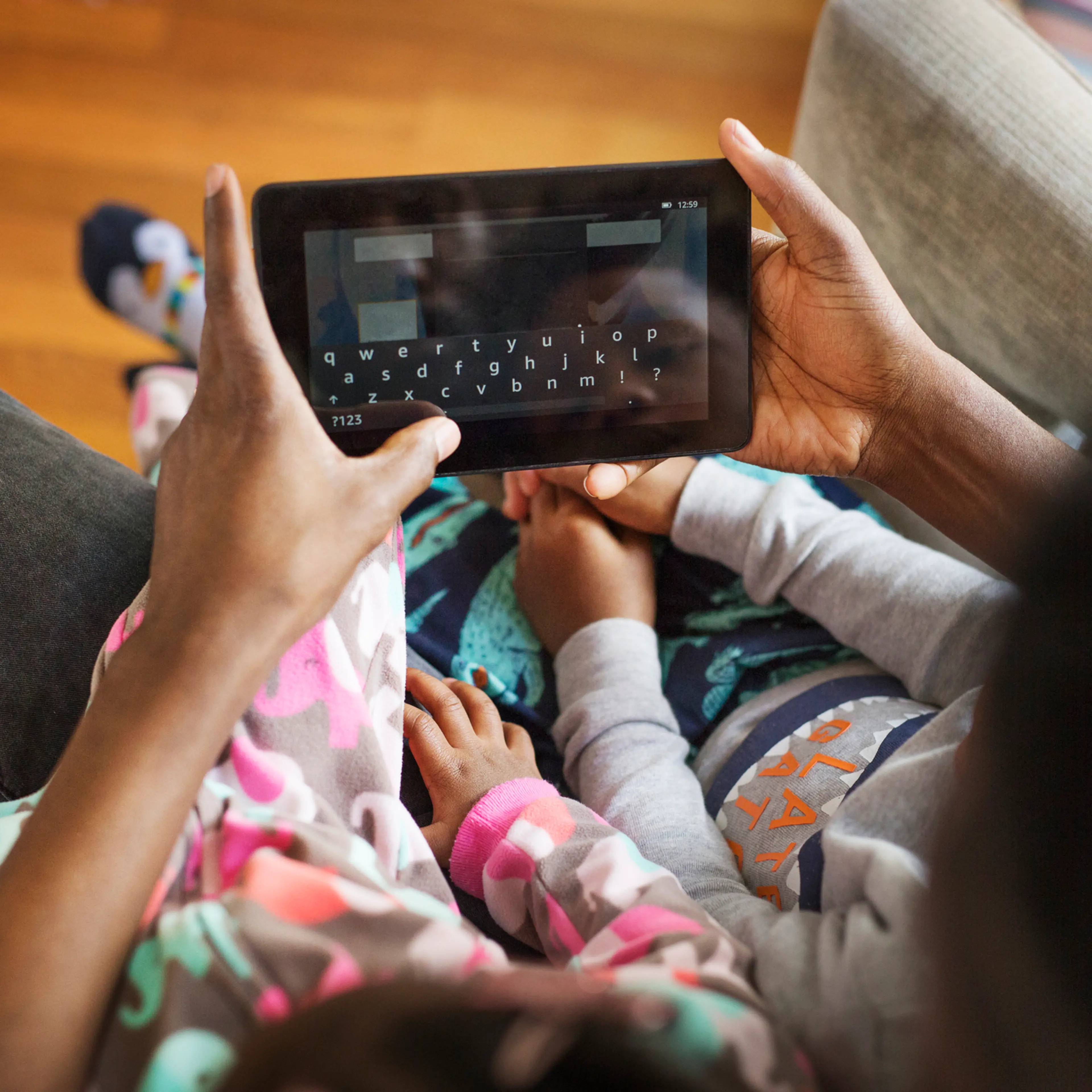 View of a parent using tablet computer with a child at home