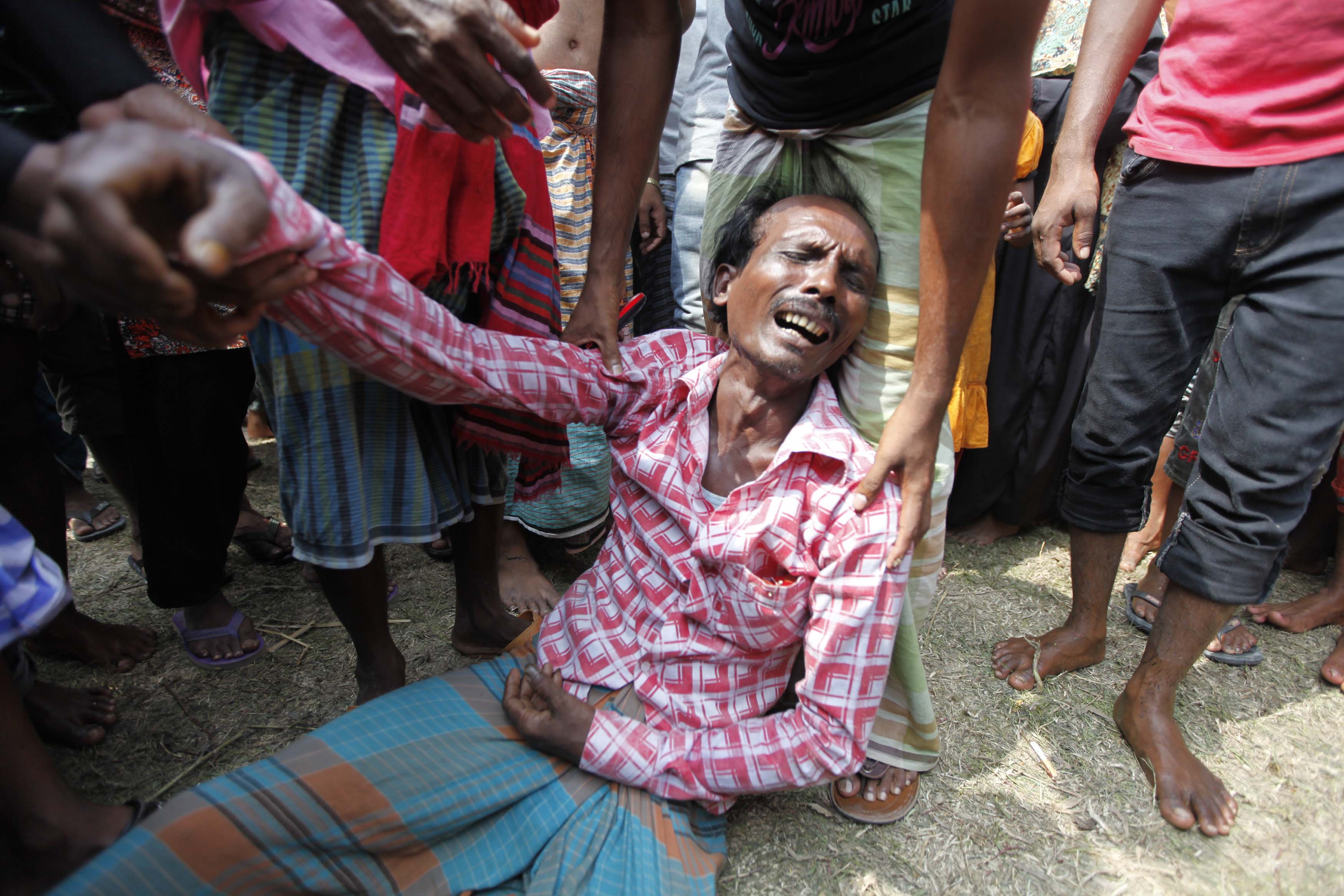A relative mourns as he waits for the news of his brother, who was a passenger of the M.V. Miraj-4 ferry which capsized, by the Meghna river at Rasulpur in Munshiganj district