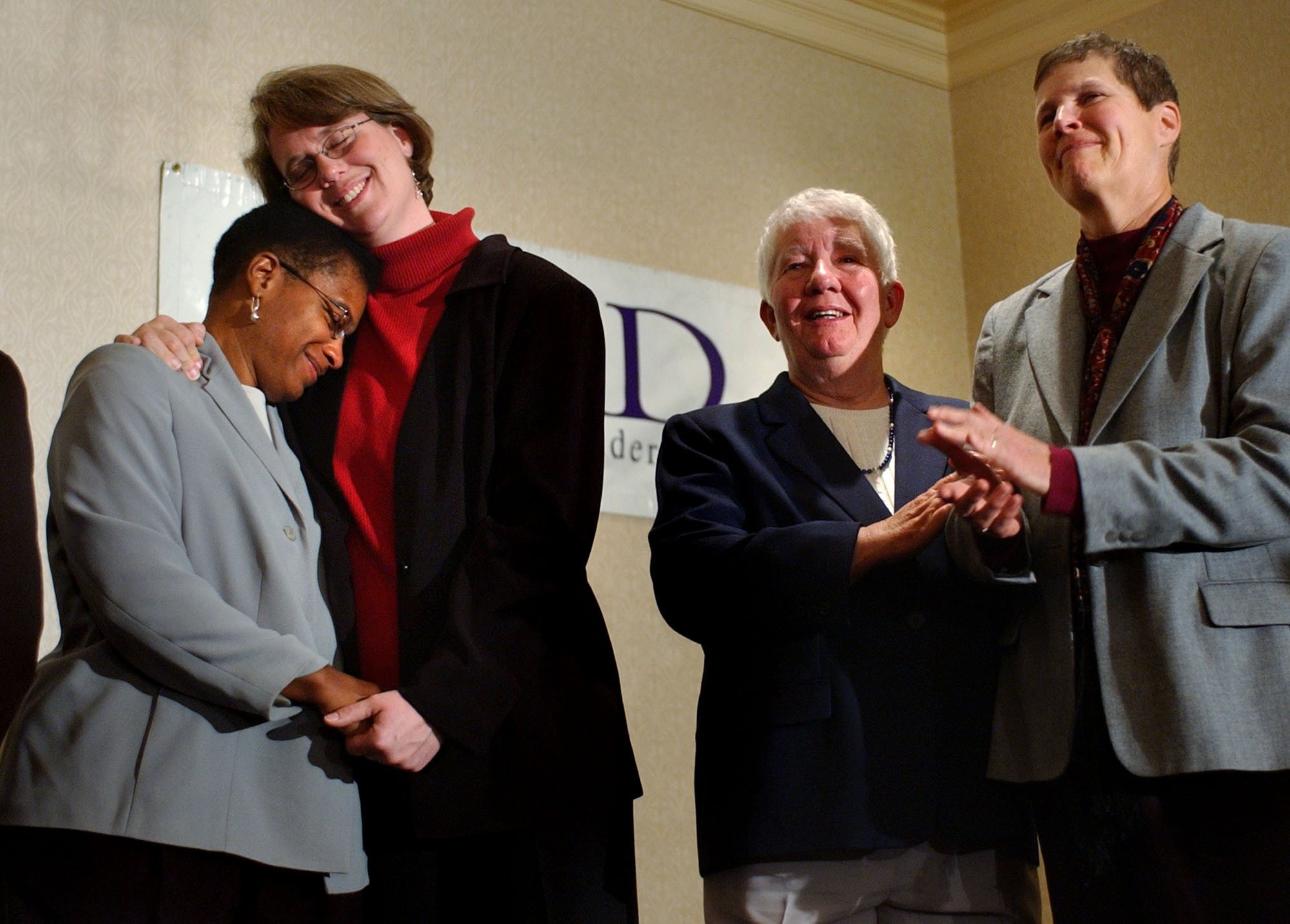 Heidi Norton, second from left, hugs her partner Gina Smith, both of Northampton, Mass., during a news conference in Boston regarding the Massachusetts Supreme Judicial Court's ruling that same-sex couples are legally entitled to wed under the state constitution on Nov. 18, 2003.