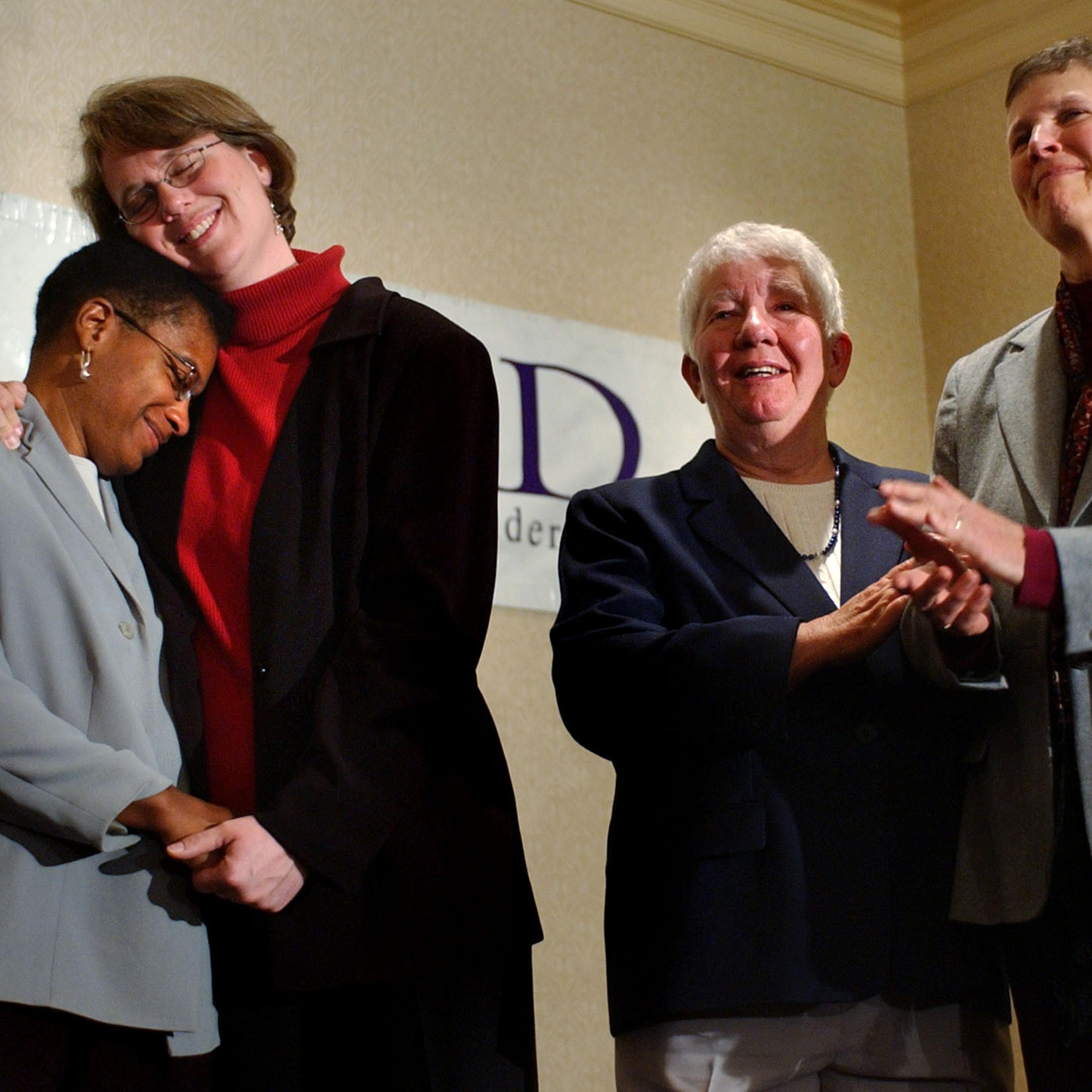 Heidi Norton, second from left, hugs her partner Gina Smith, both of Northampton, Mass., during a news conference in Boston regarding the Massachusetts Supreme Judicial Court's ruling that same-sex couples are legally entitled to wed under the state constitution on Nov. 18, 2003.