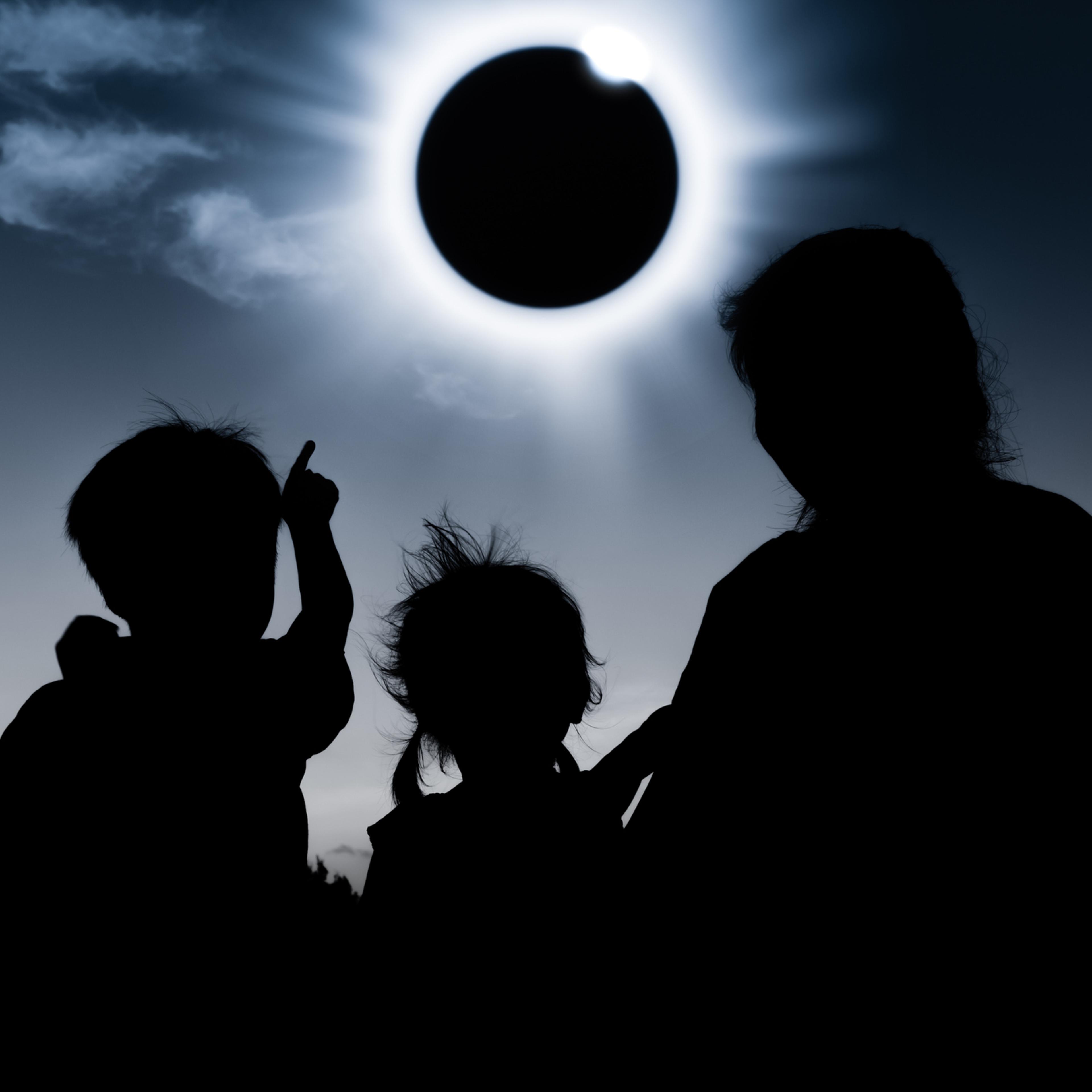 Natural phenomenon. Silhouette of family sitting and relaxing together.