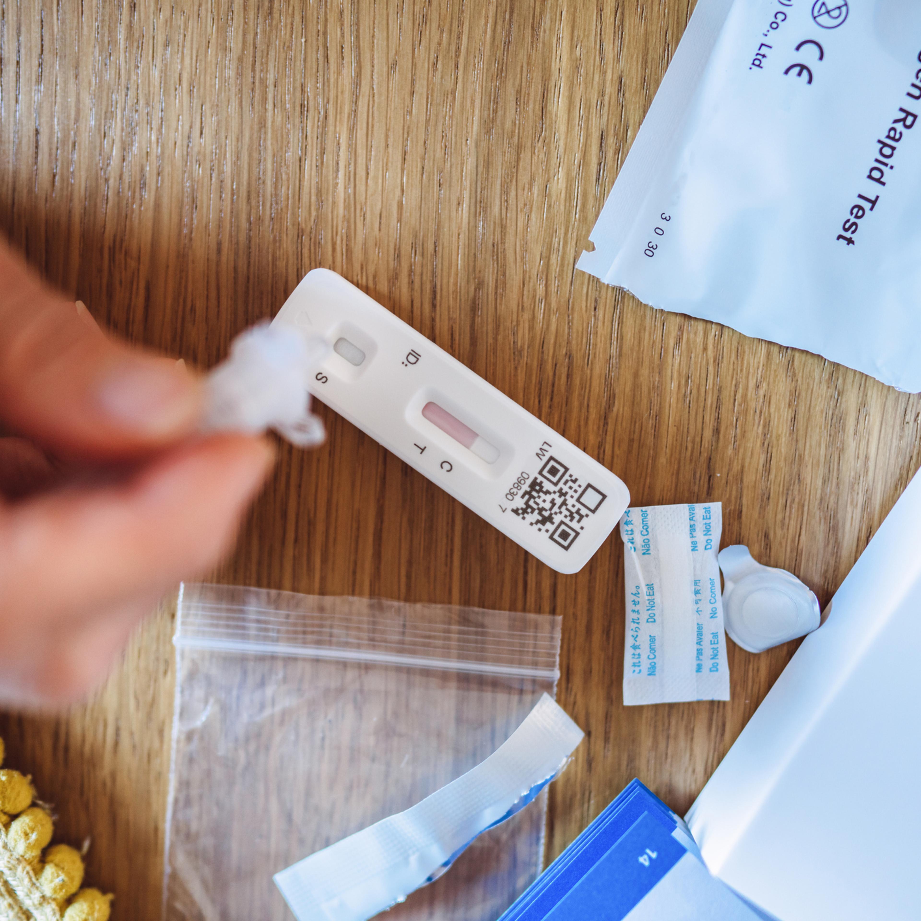 A woman using a Covid-19 rapid self-test kit at home