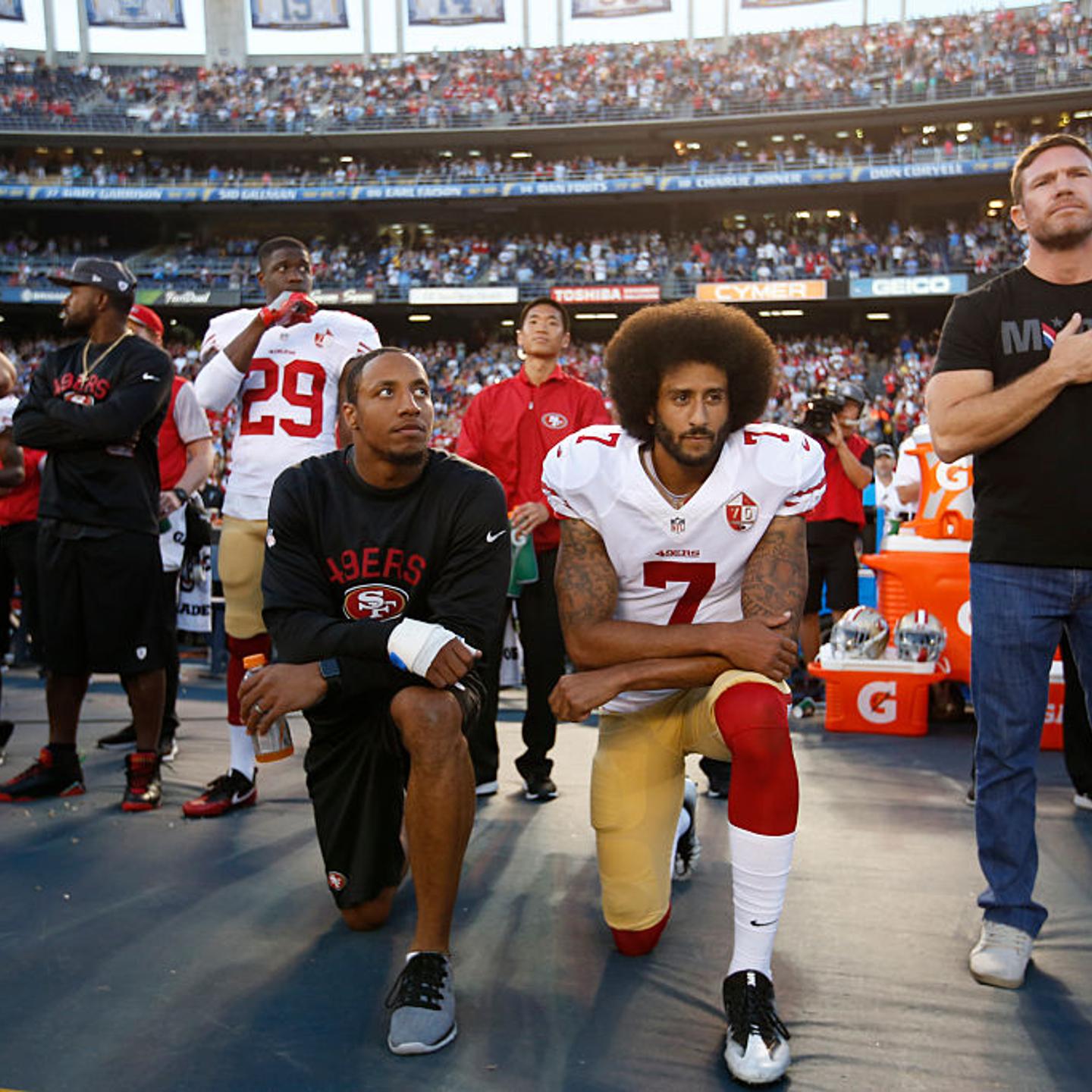 Eric Reid #35 and Colin Kaepernick #7 of the San Francisco 49ers kneel on the sideline during the anthem, as free agent Nate Boyer stands, prior to the game against the San Diego Chargers at Qualcomm Stadium in San Diego, Calif., on Sept. 1, 2016.