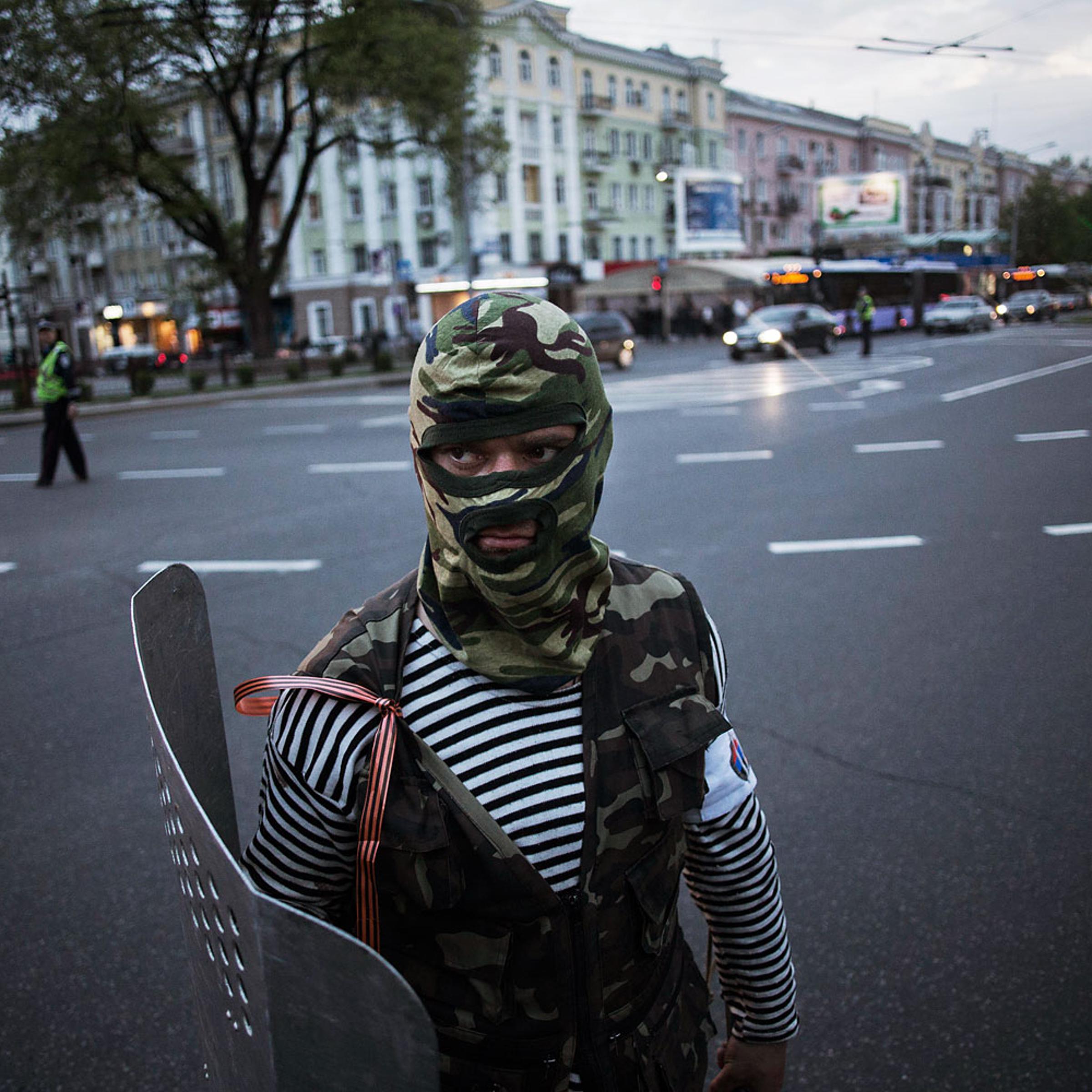 A pro-Russian activist is seen while holding a shield after clashing with pro Ukrainians during a pro Ukraine rally in Donetsk, Ukraine, Monday, April 28, 2014.