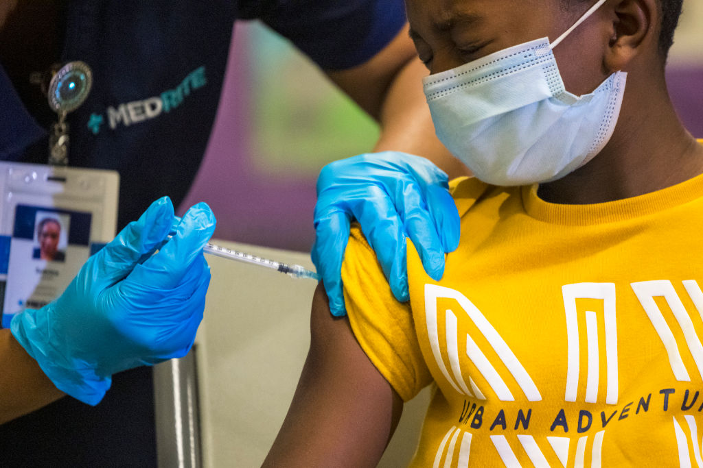 An 8-year old winces as he receives a COVID-19 shot at a vaccination event at a New York City public school on Nov. 8, 2021.
