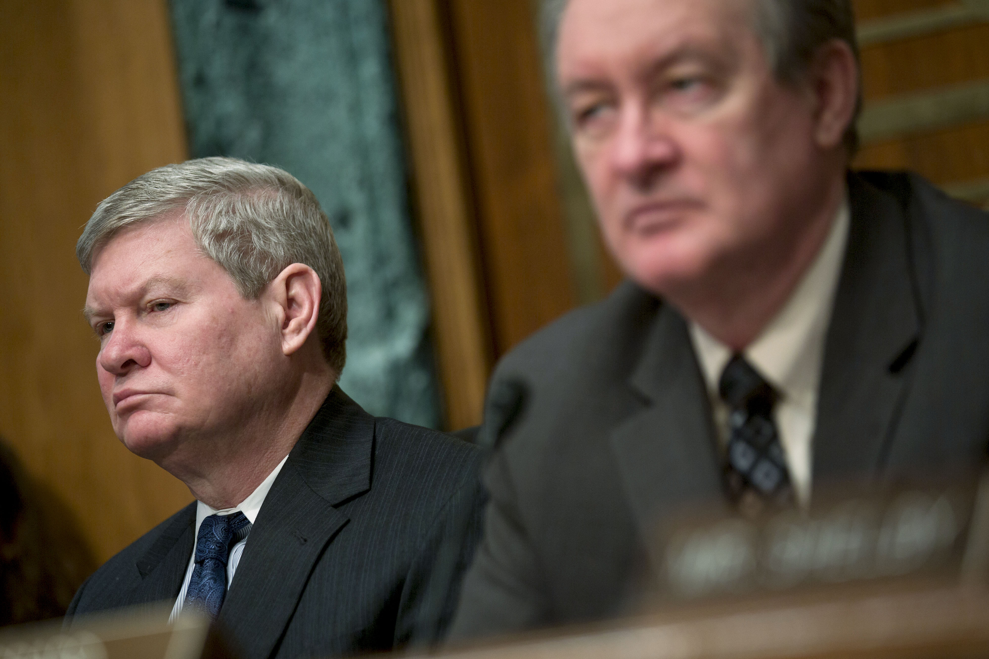 Senator Tim Johnson, chairman of the Senate Banking Committee, left, and Senator Mike Crapo listen during a Senate Banking Committee hearing in Washington, Feb. 27, 2014.