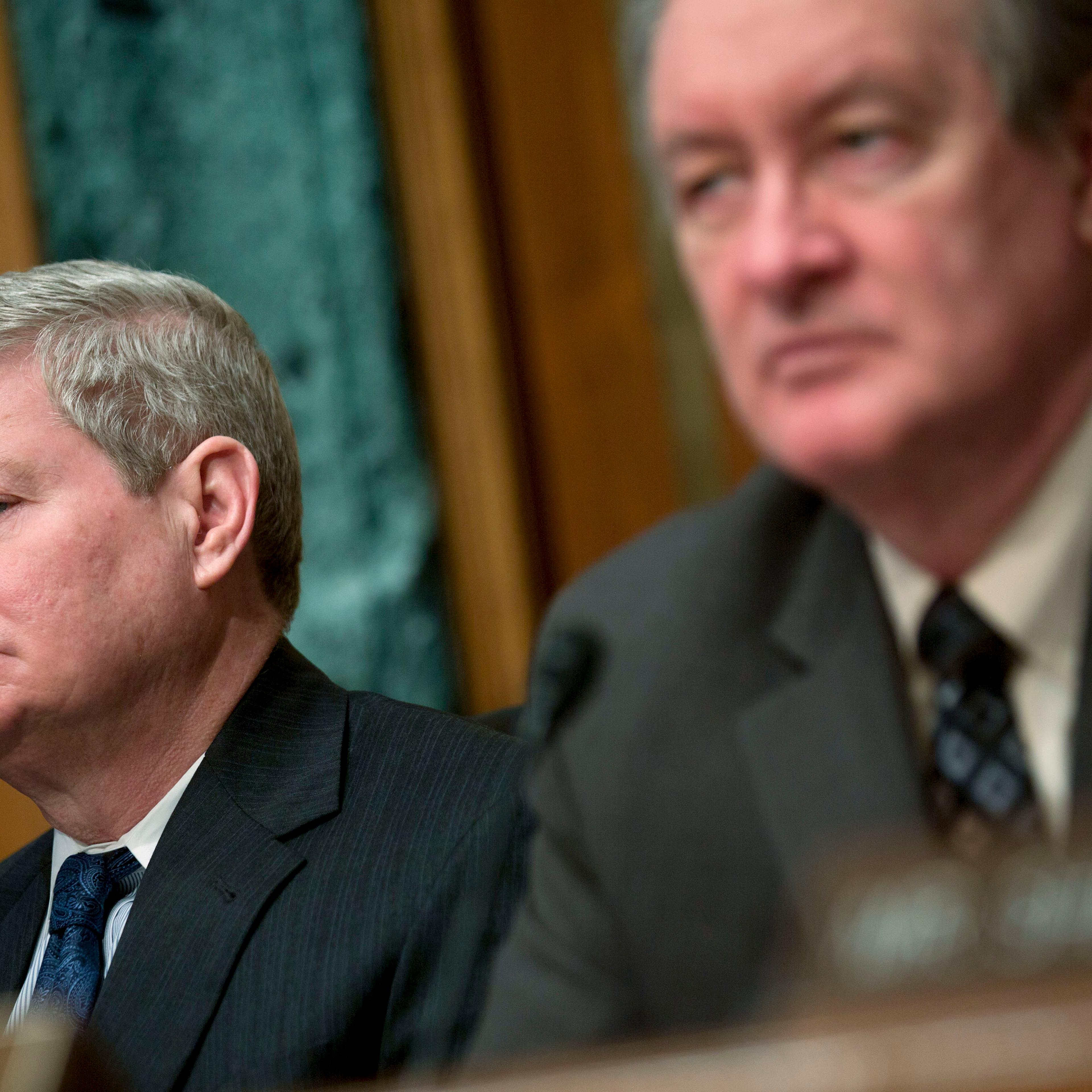 Senator Tim Johnson, chairman of the Senate Banking Committee, left, and Senator Mike Crapo listen during a Senate Banking Committee hearing in Washington, Feb. 27, 2014.