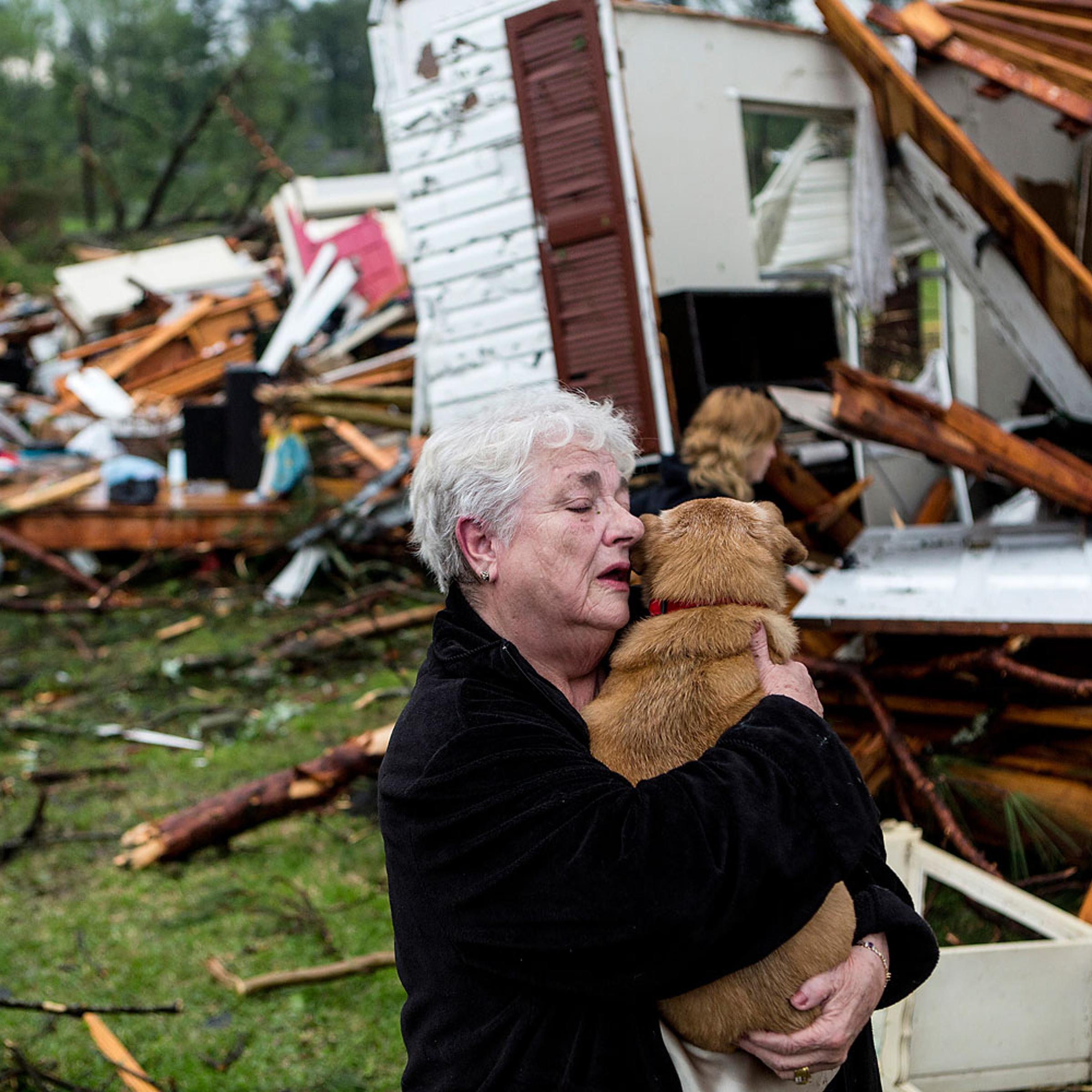 Constance Lambert embraces her dog after finding it alive when returning to her destroyed home in Tupelo, Miss., April 28, 2014.