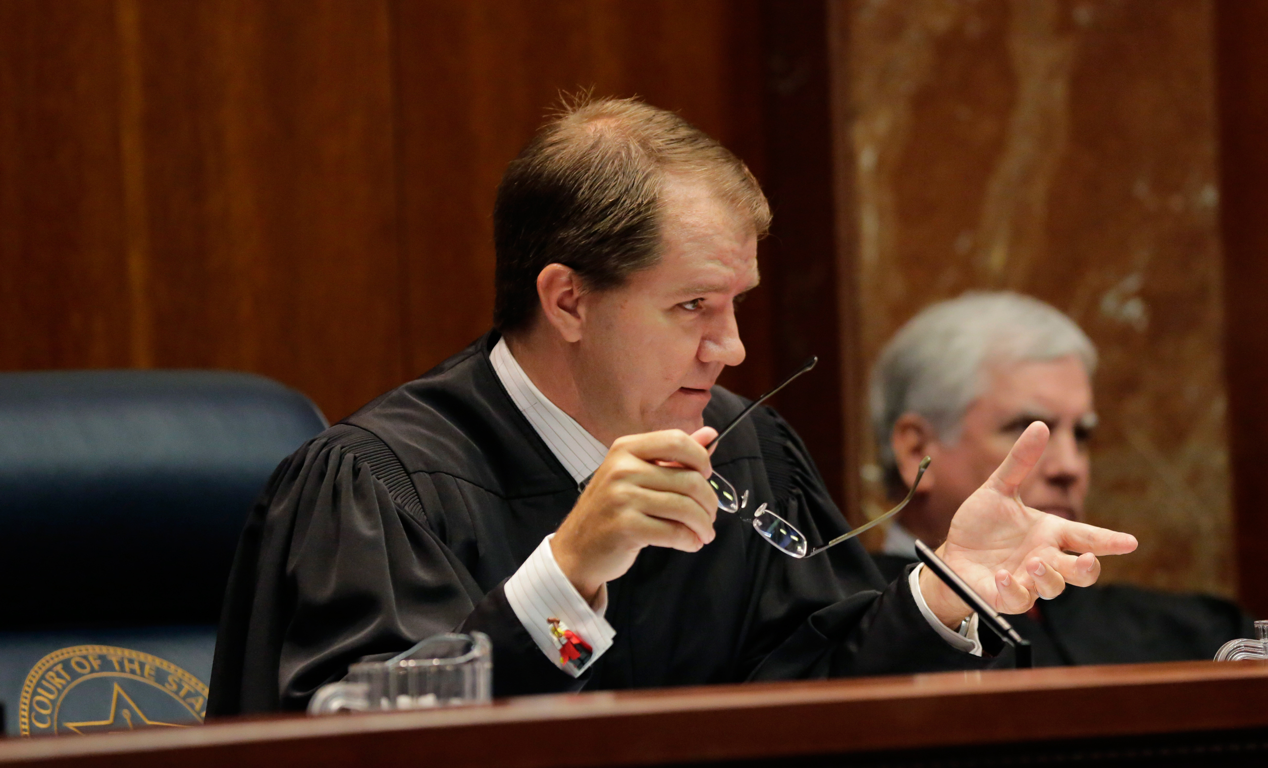 Texas Supreme Court Justice Don Willett, left, asks a question during oral arguments in Texas' latest school finance case at the state Supreme Court, Tuesday, Sept. 1, 2015, in Austin, Texas. Attorneys for more than 600 school districts suing Texas argue