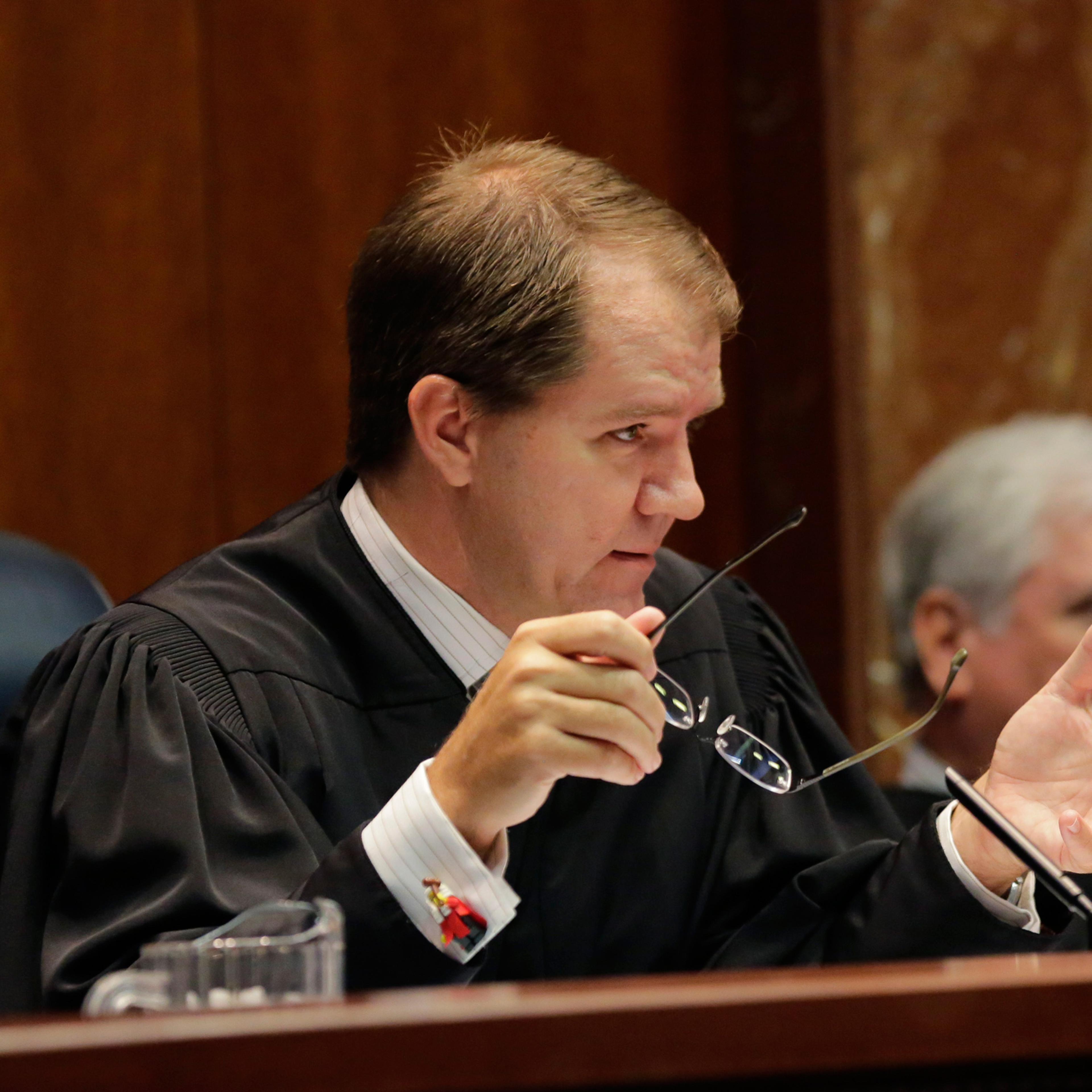 Texas Supreme Court Justice Don Willett, left, asks a question during oral arguments in Texas' latest school finance case at the state Supreme Court, Tuesday, Sept. 1, 2015, in Austin, Texas. Attorneys for more than 600 school districts suing Texas argue