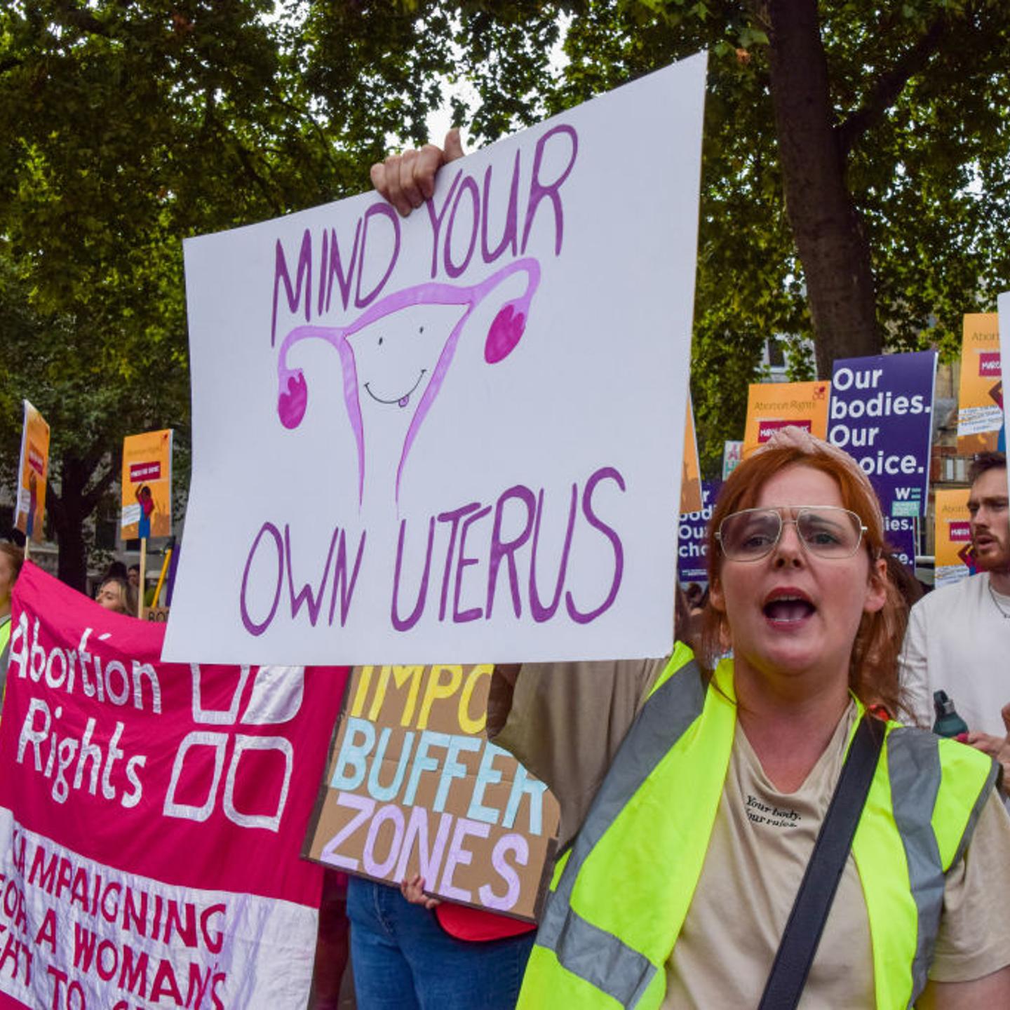A pro-choice protester holds a placard which states "Mind