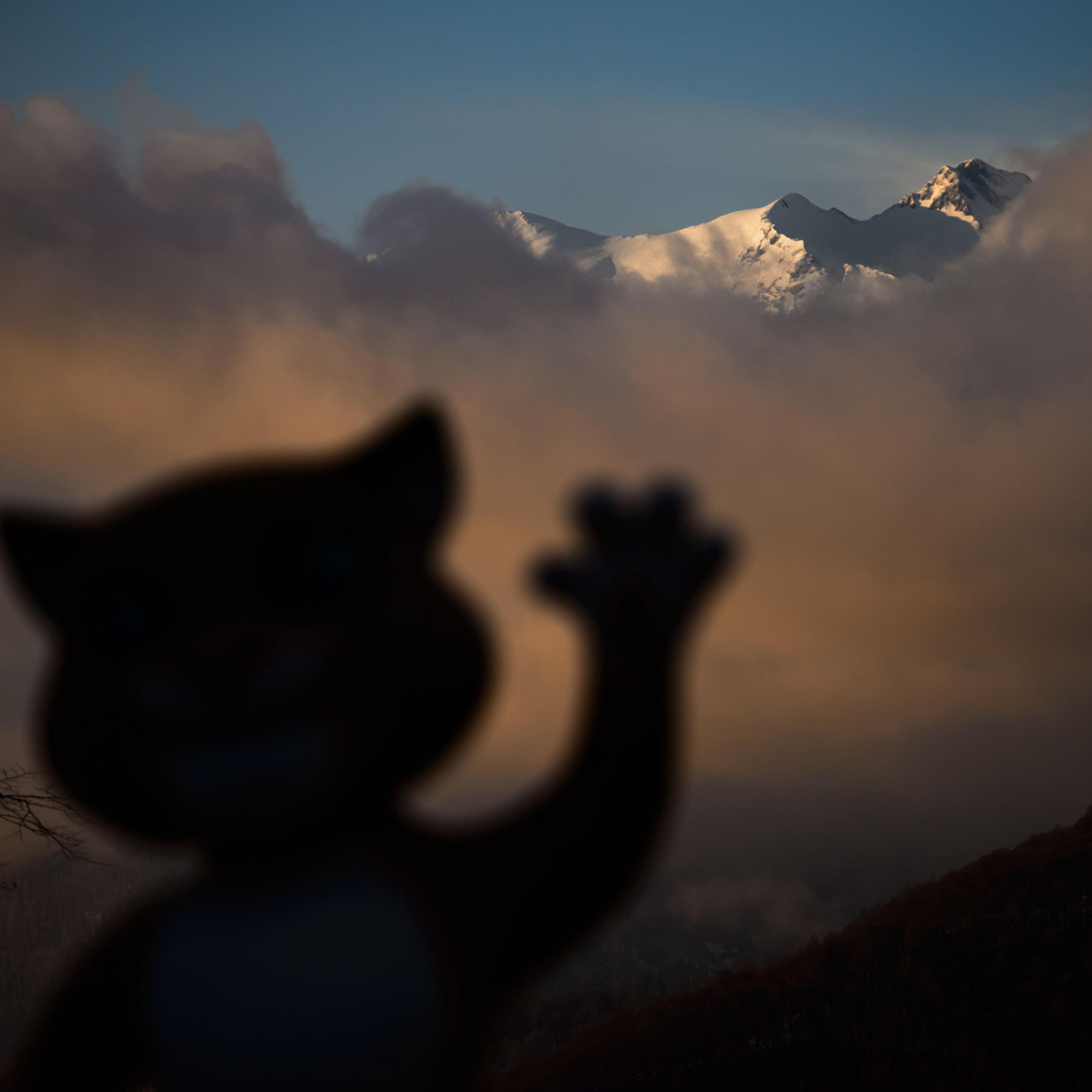 A mascot of Sochi Winter Olympics is seen in silhouette with mountains at sunset at the Mountain athletes village during the Sochi Winter Olympics on Feb. 11, 2014.
