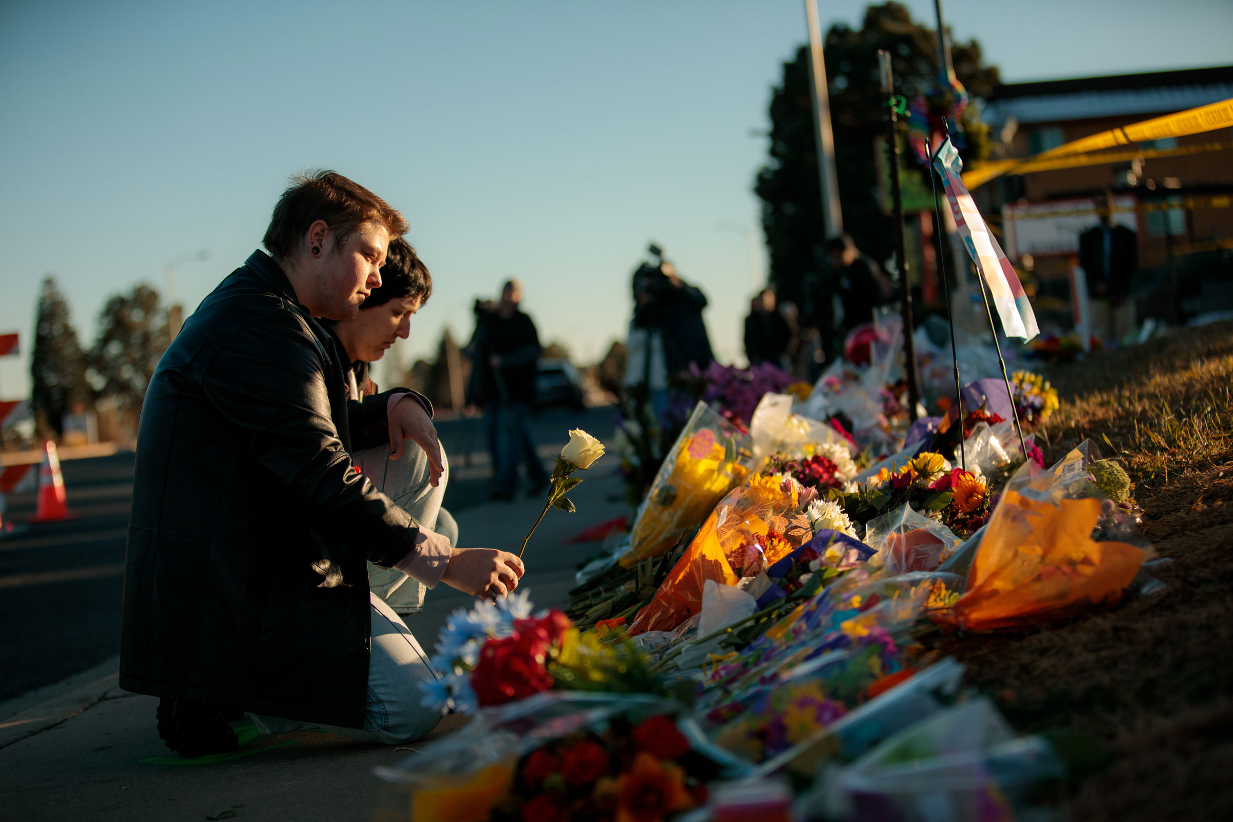 Ren Kurgis, left, and Jessie Pacheco leave flowers at the growing memorial near the scene of the shooting inside Club Q in Colorado Springs, Colo., on Sunday, Nov. 20, 2022.