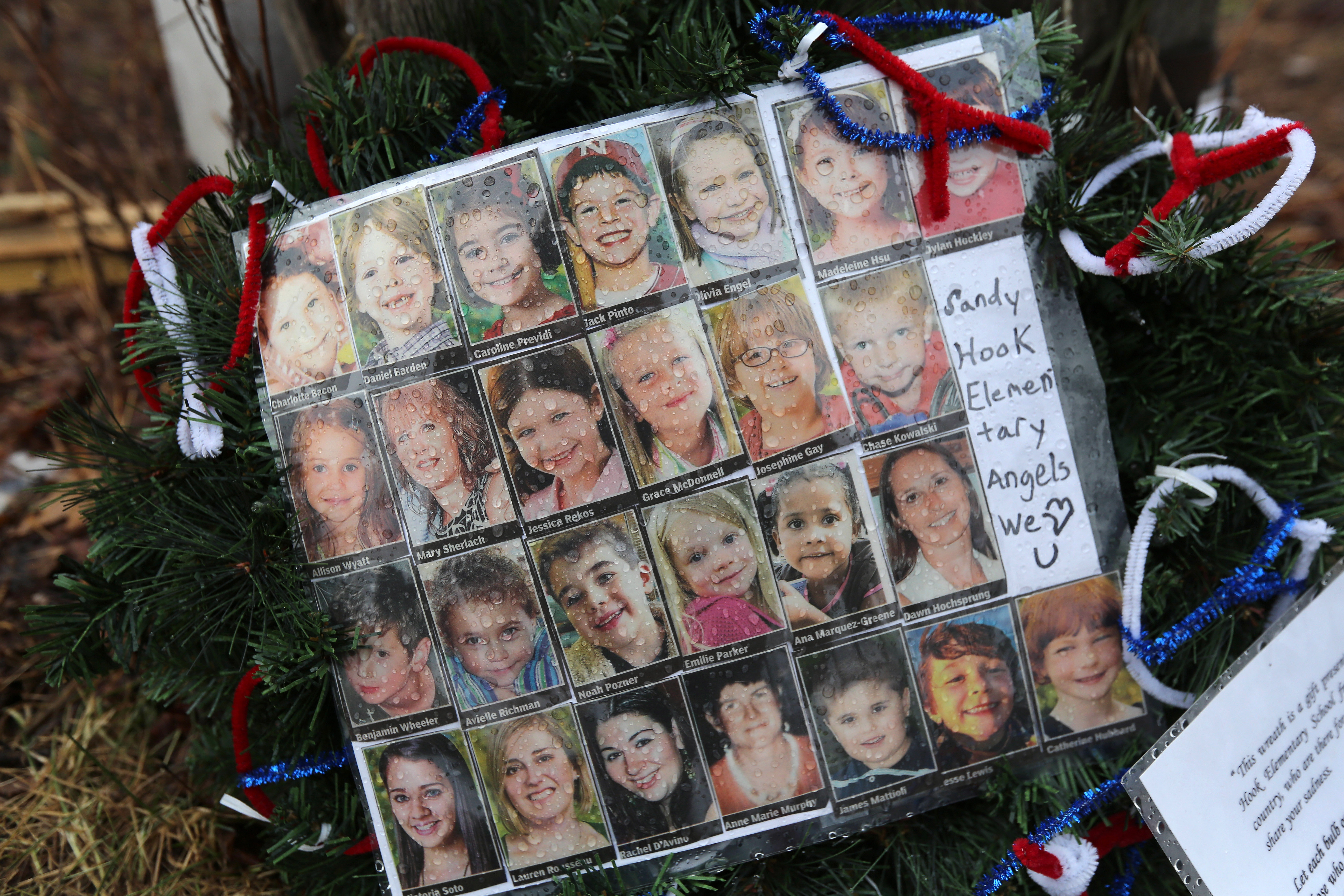 NEWTOWN, CT - JANUARY 14:  Photos of Sandy Hook Elementary School massacre victims sits at a small memorial near the school on January 14, 2013 in Newtown, Connecticut. The town marked a month anniversay since the massacre of 26 children and adults at th