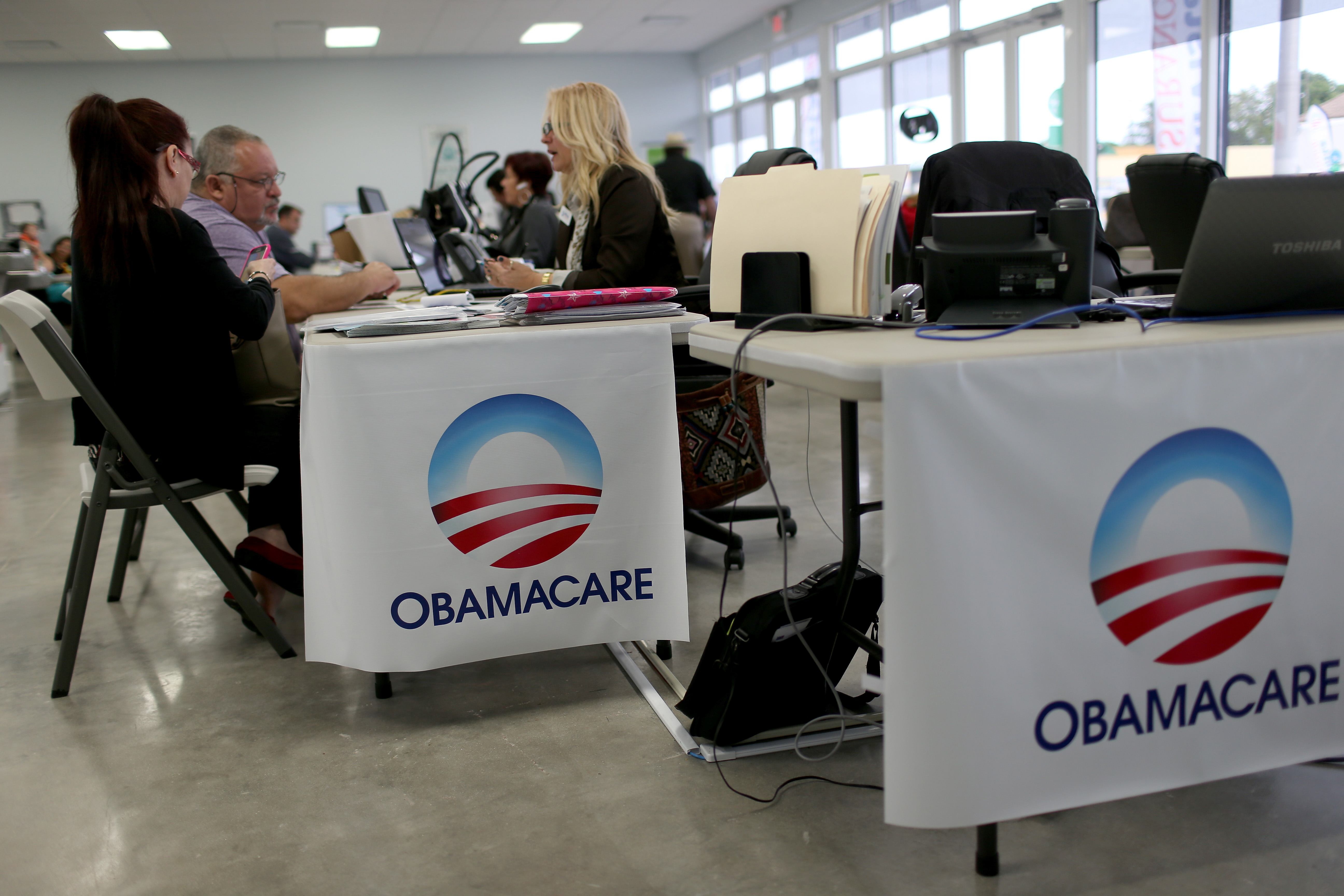 Aymara Marchante (L) and Wiktor Garcia sit with Maria Elena Santa Coloma, an insurance advisor with UniVista Insurance company, as they sign up for the Affordable Care Act, also known as Obamacare, before the February 15th deadline on February 5, 2015 in