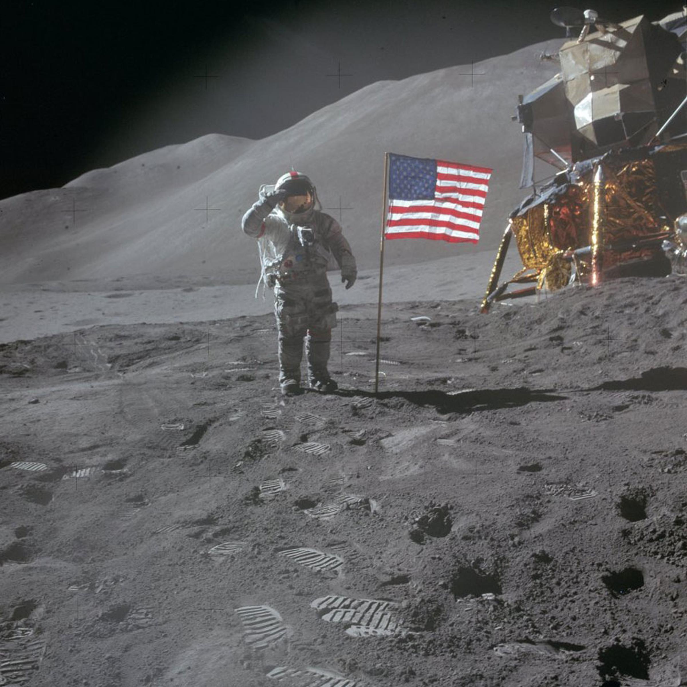 Scott salutes the flag after exiting the LEM and beginning his and Irwin's third trek of their lunar stay. Angled sunlight washes through the red, white and blue.